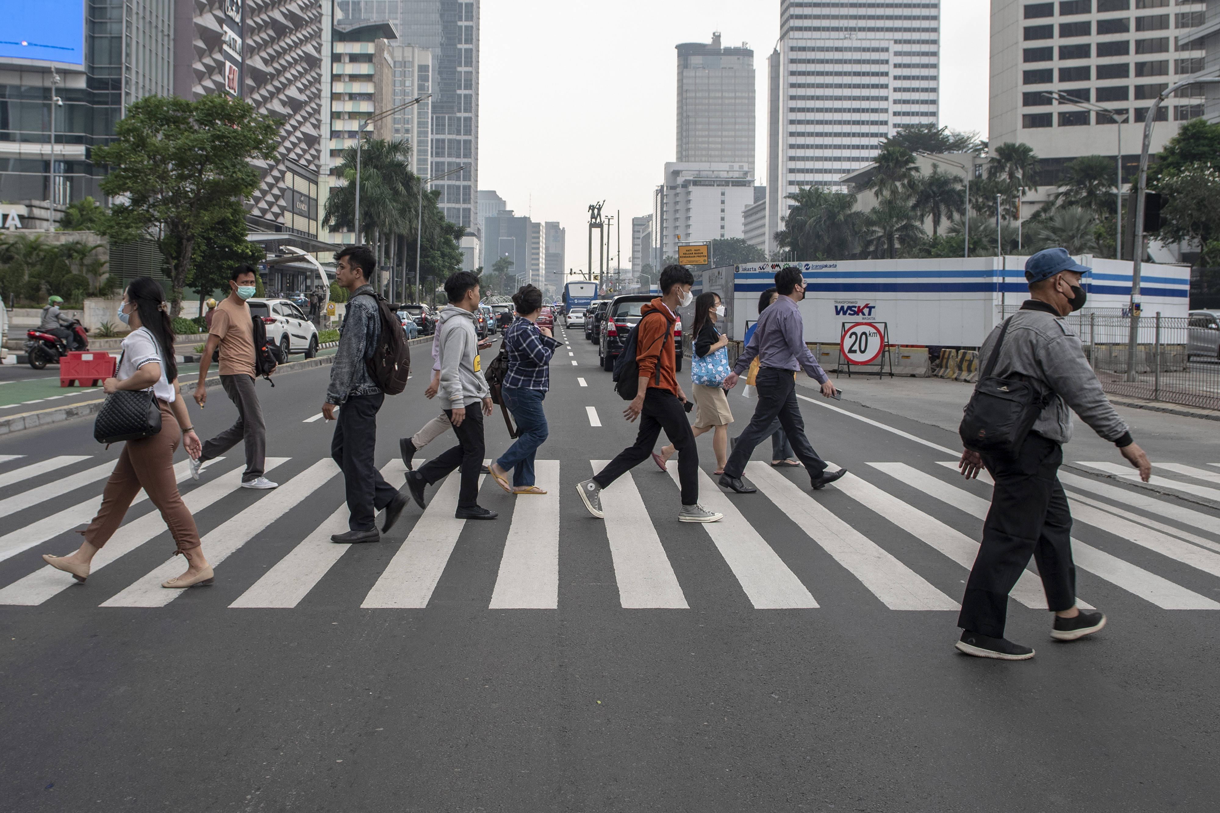 Sejumlah karyawan perkantoran menyeberangi pelican crossing saat jam masuk kerja di Jakarta.