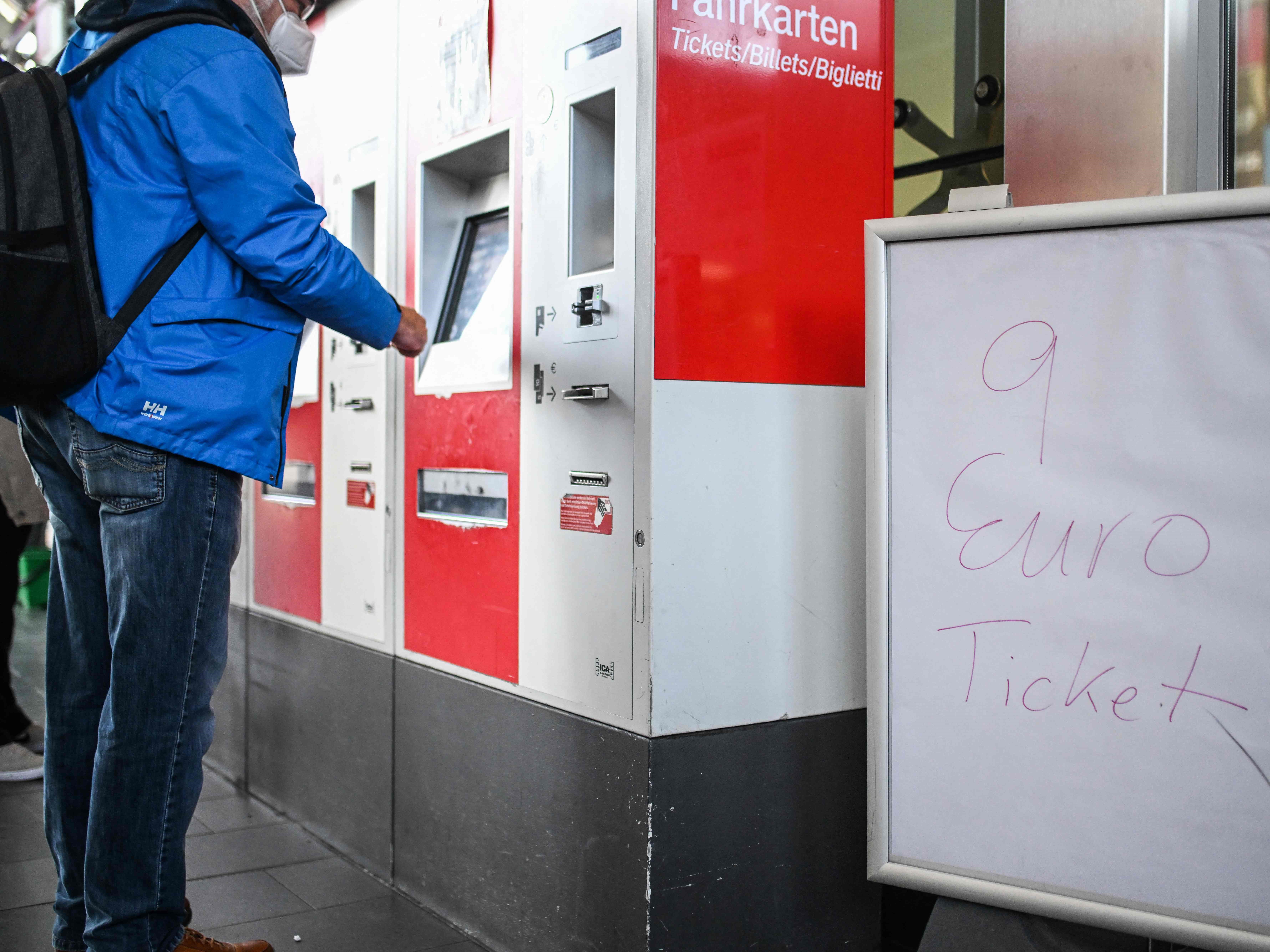 Seorang pria berdiri di depan mesin tiket di stasiun kereta api, Jerman. 