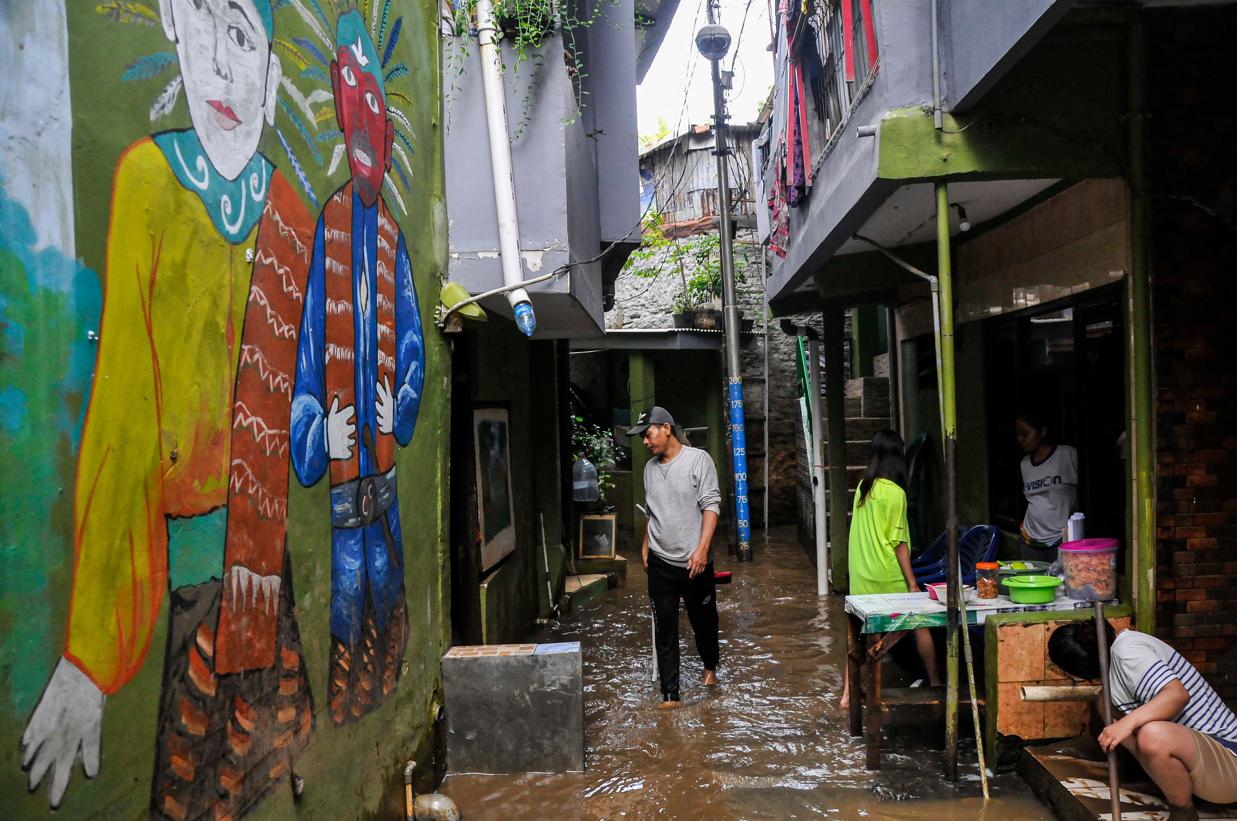Warga membersihkan lumpur saat banjir menggenangi wilayah Kebon Pala, Jatinegara, Jakarta Timur.