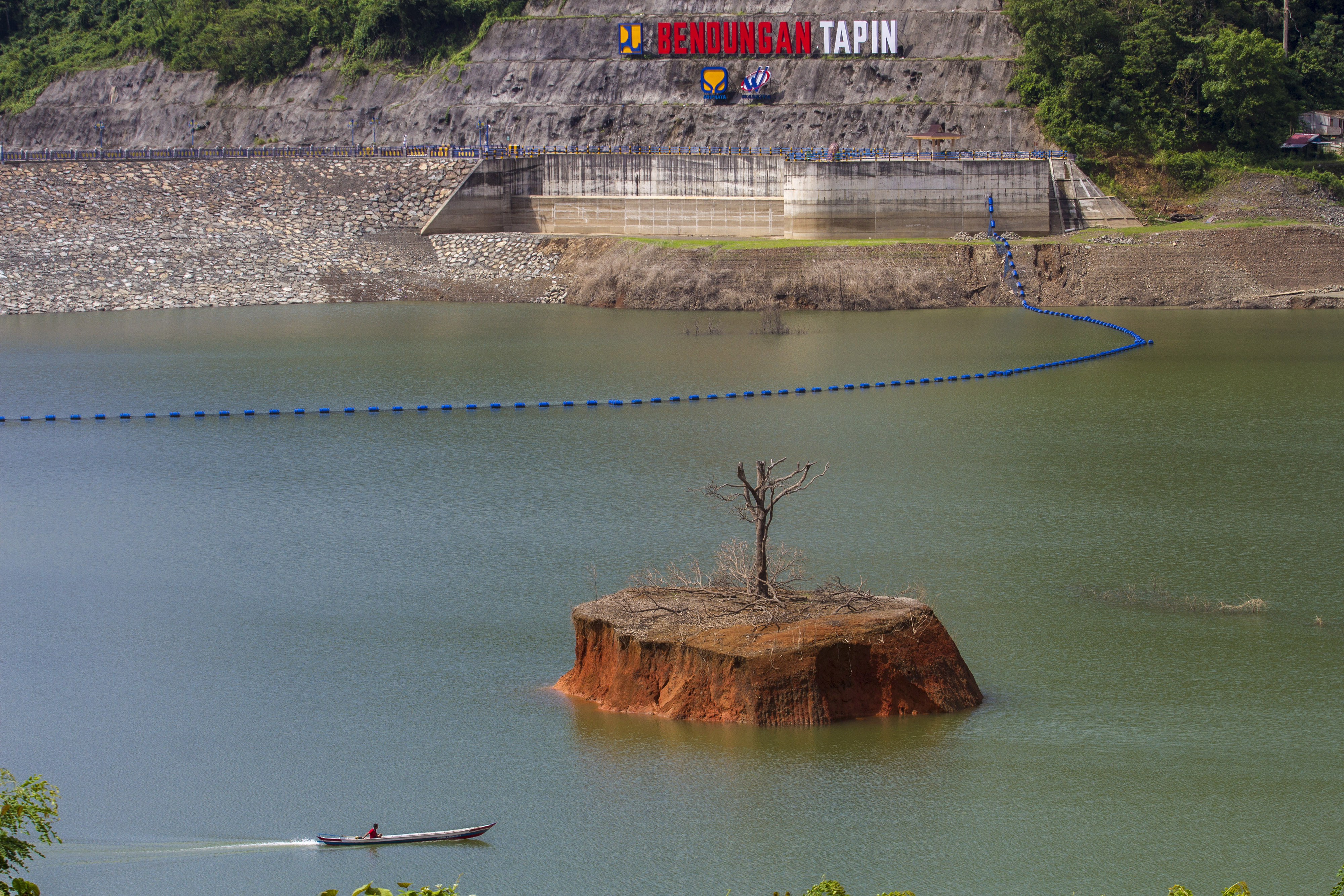 Warga menggunakan perahu bermesin melintas di kawasan Bendungan Tapin di Kecamatan Piani, Kabupaten Tapin, Kalimantan Selatan. 