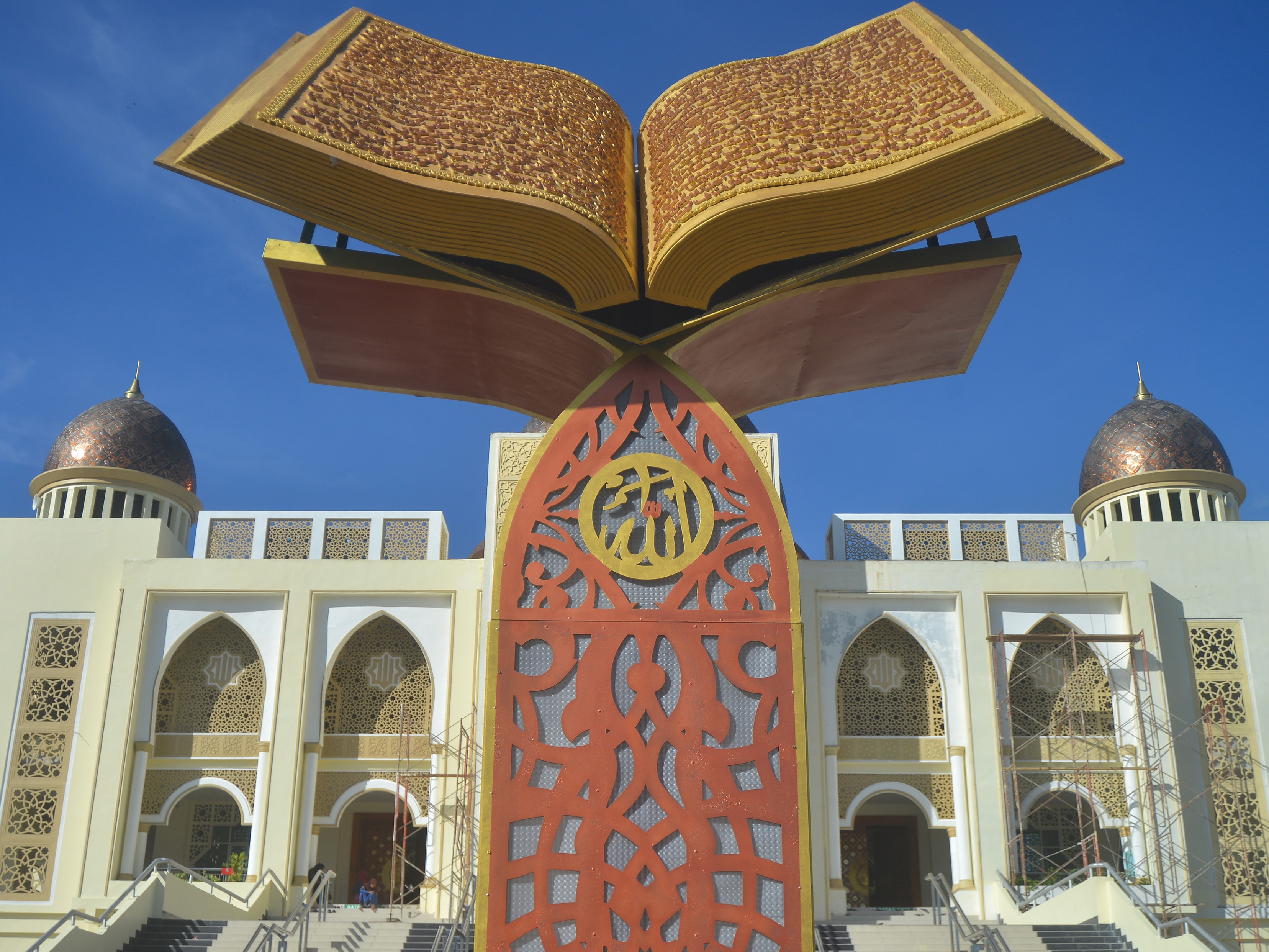 Warga duduk di belakang monumen Al-Qur'an kawasan Islamic Center Kota Padang Panjang, Sumatra Barat, Rabu (24/7/2022).