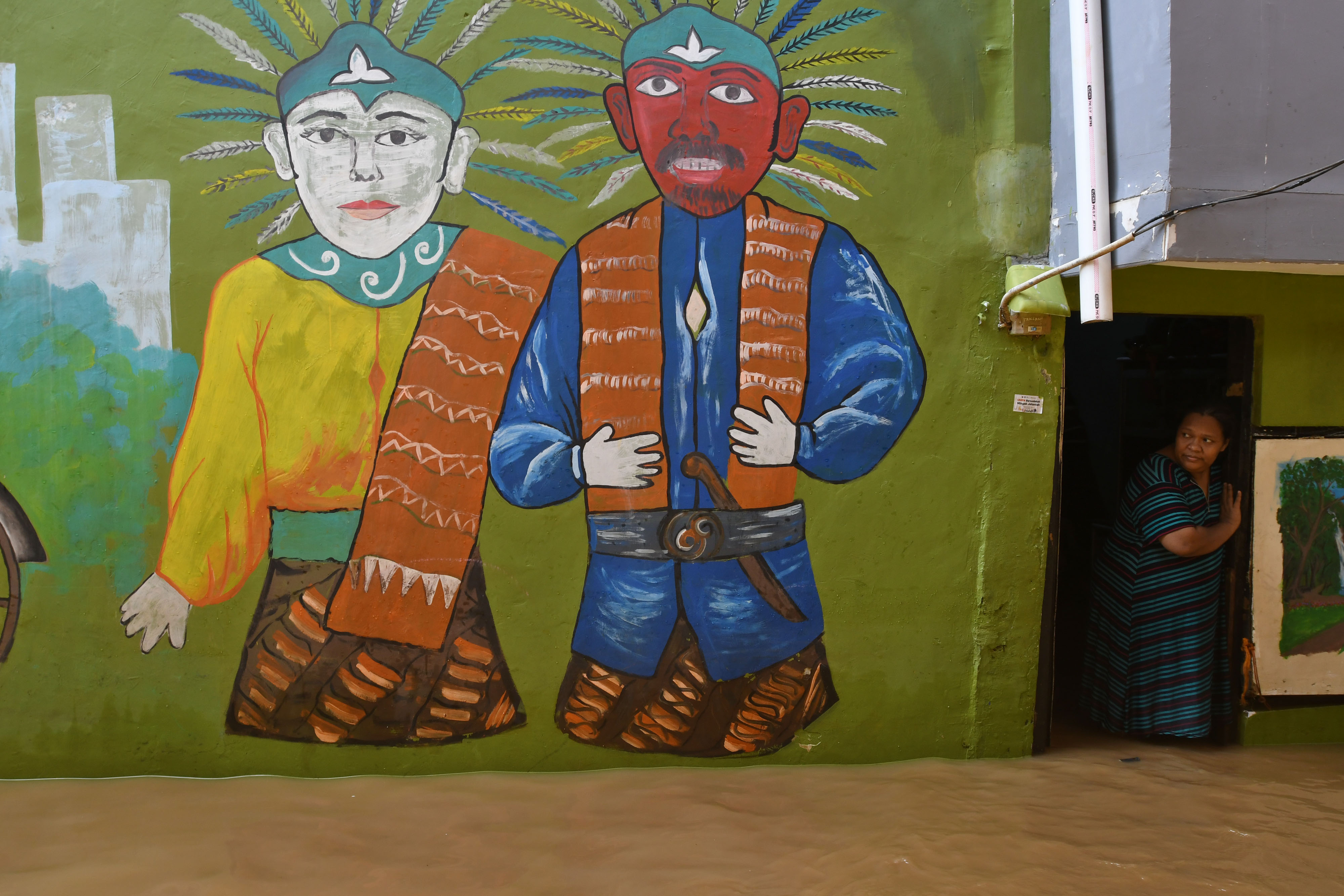 Seorang ibu menengok kondisi banjir yang melanda perkampungan padat penduduk di Kebon Pala, Kampung Melayu, Jakarta Timur