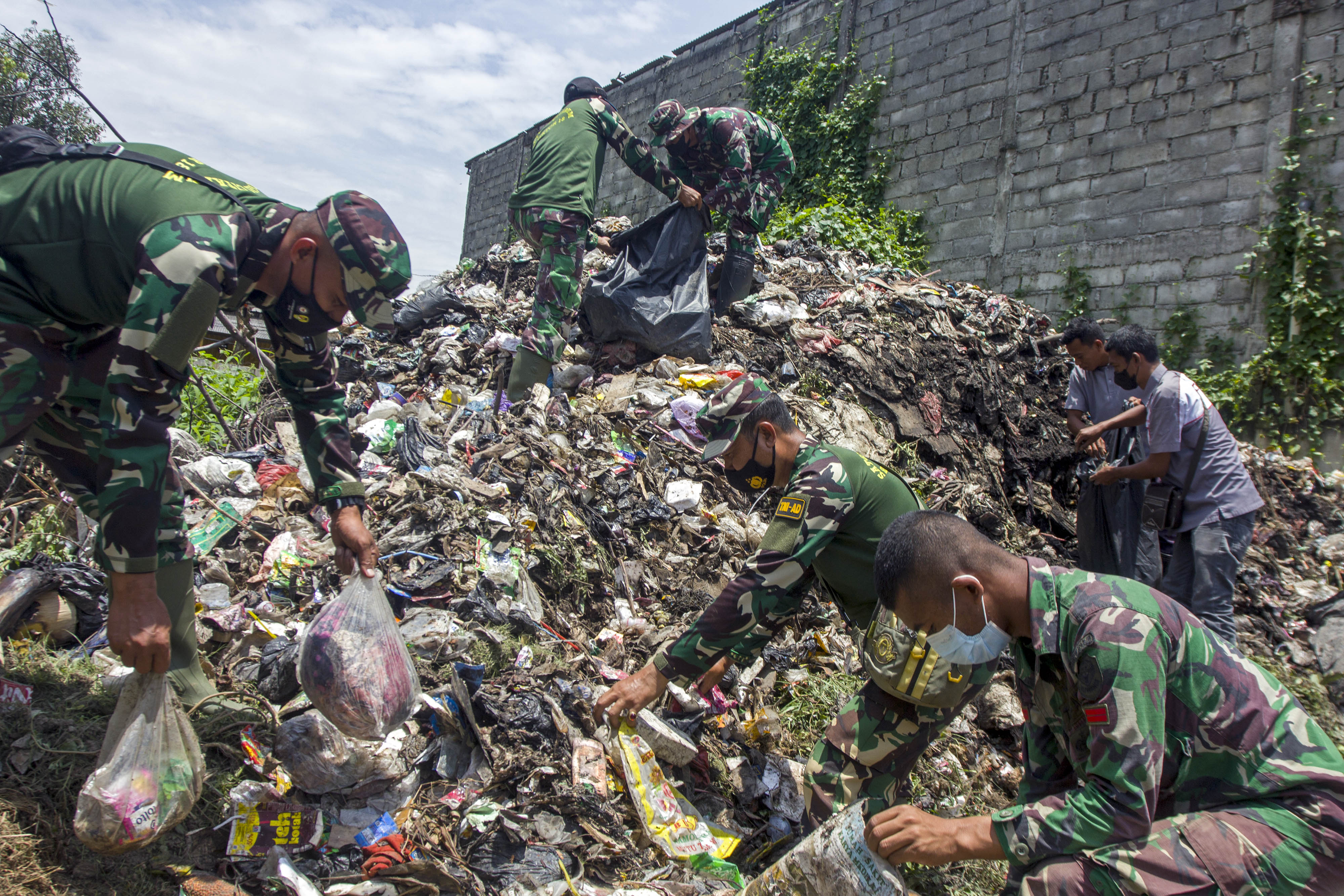 Anggota Satgas Citarum Harum memungut sampah di wilayah bantaran Sungai Citarum, Desa Anggadita, Karawang, Jawa Barat.