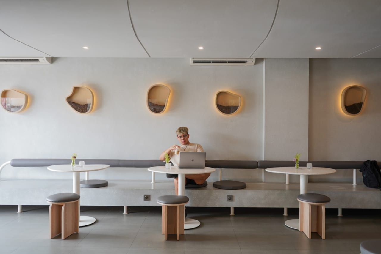 Seorang pengunjung sedang menikmati sajian kopi sembari bekerja di Oddity Coffee Kelapa Gading, Jakarta Utara.