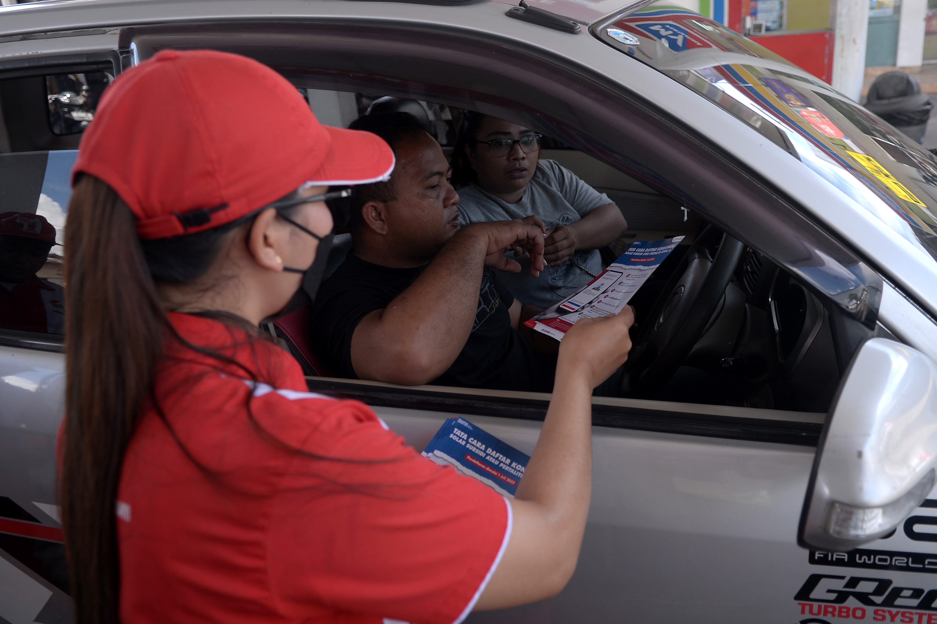 Petugas membagikan selebaran tata cara pendaftaran pembelian BBM Subsidi di sebuah SPBU di Manado, Sulut, Jumat (1/7/2022). 