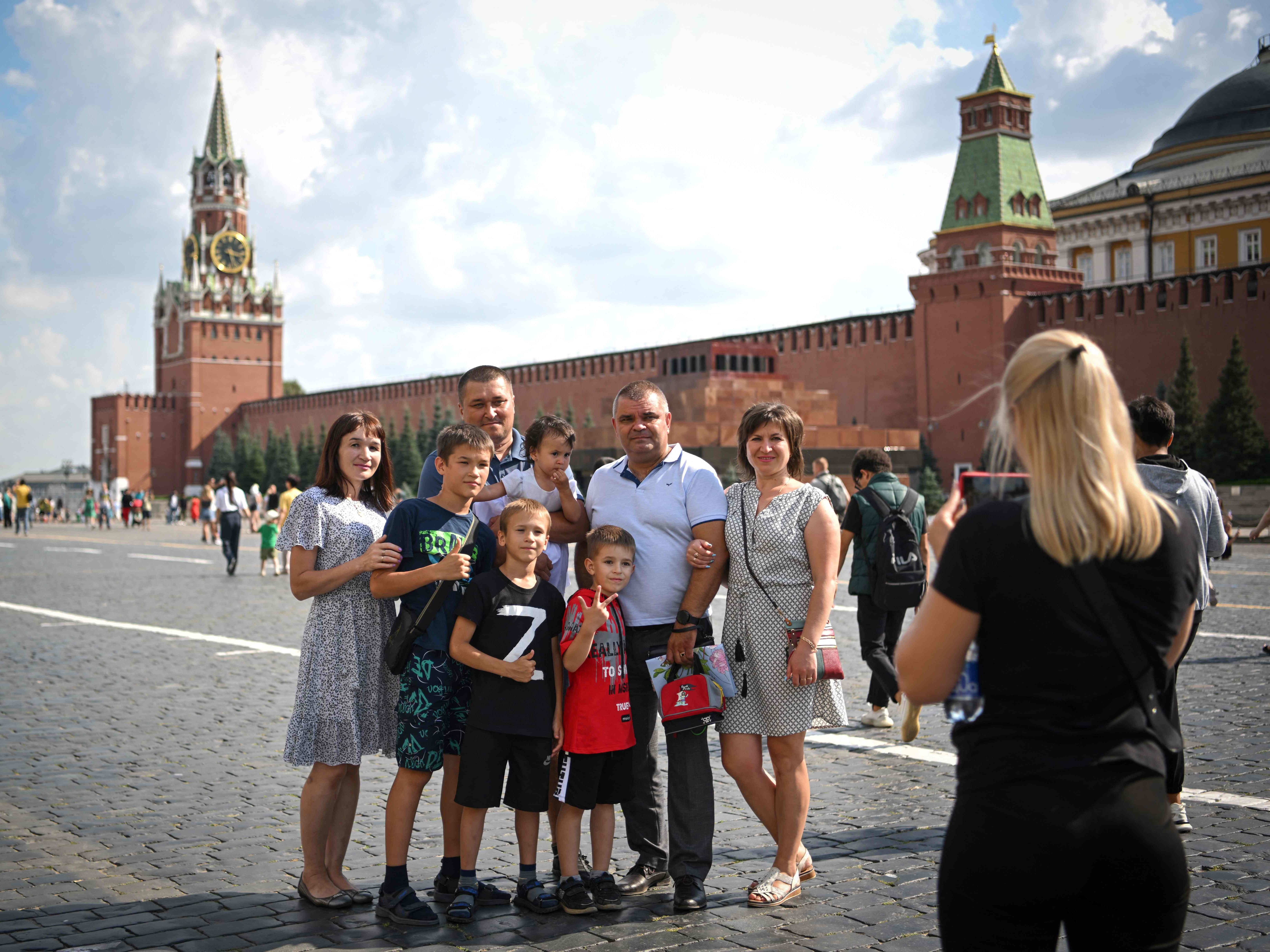 Sekelompok orang berpose di Lapangan Merah di pusat kota Moskow pada 25 Juli 2022.