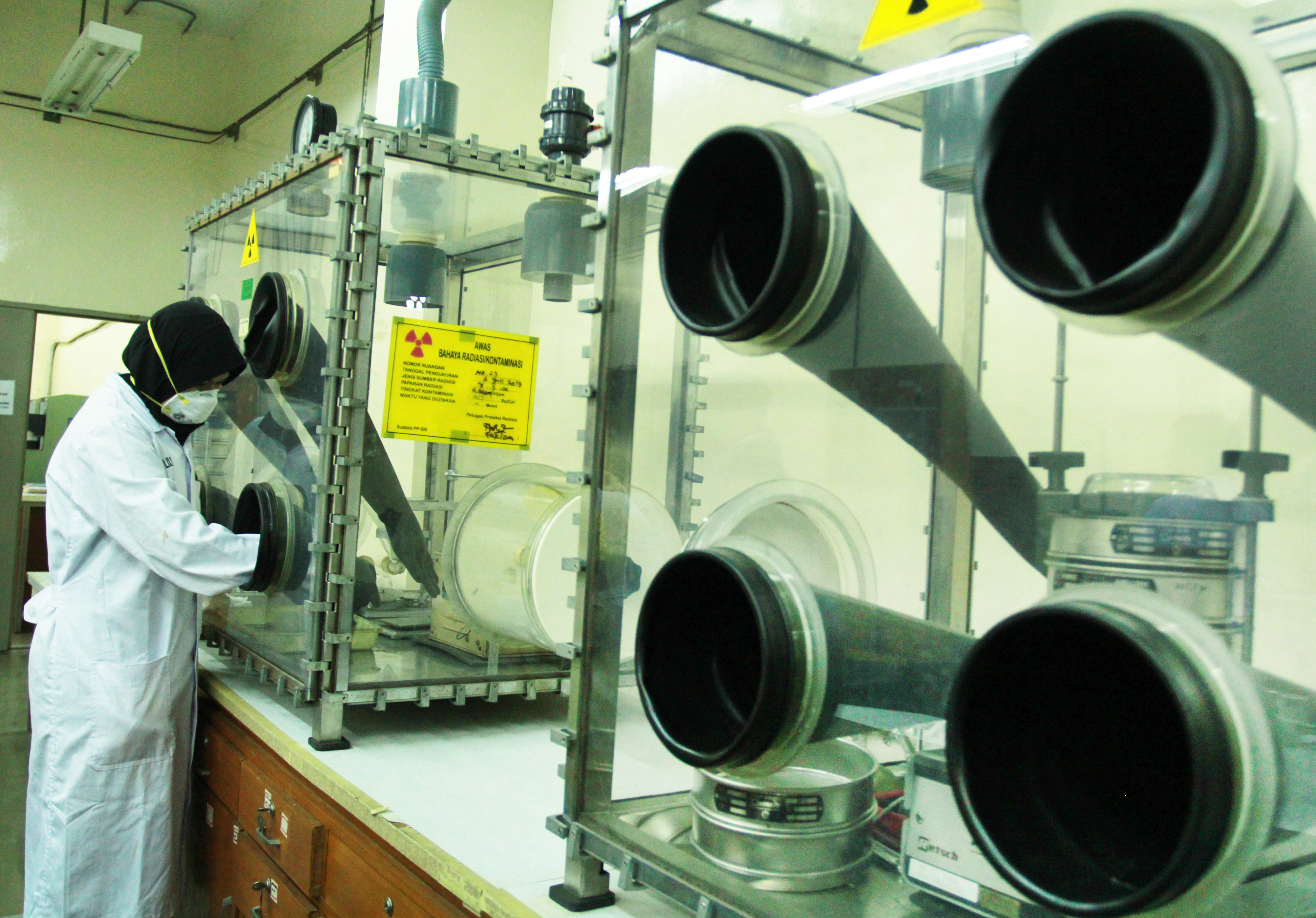 Seorang pranata nuklir melakukan pengujian kepadatan pelet dari serbuk uranium.