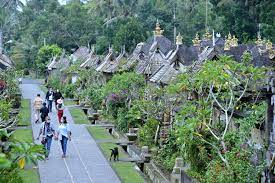 Wisatawan berjalan di sekitar deretan rumah tradisional di Desa Wisata Penglipuran, Bangli, Bali, Jumat (26/2/2021). 
