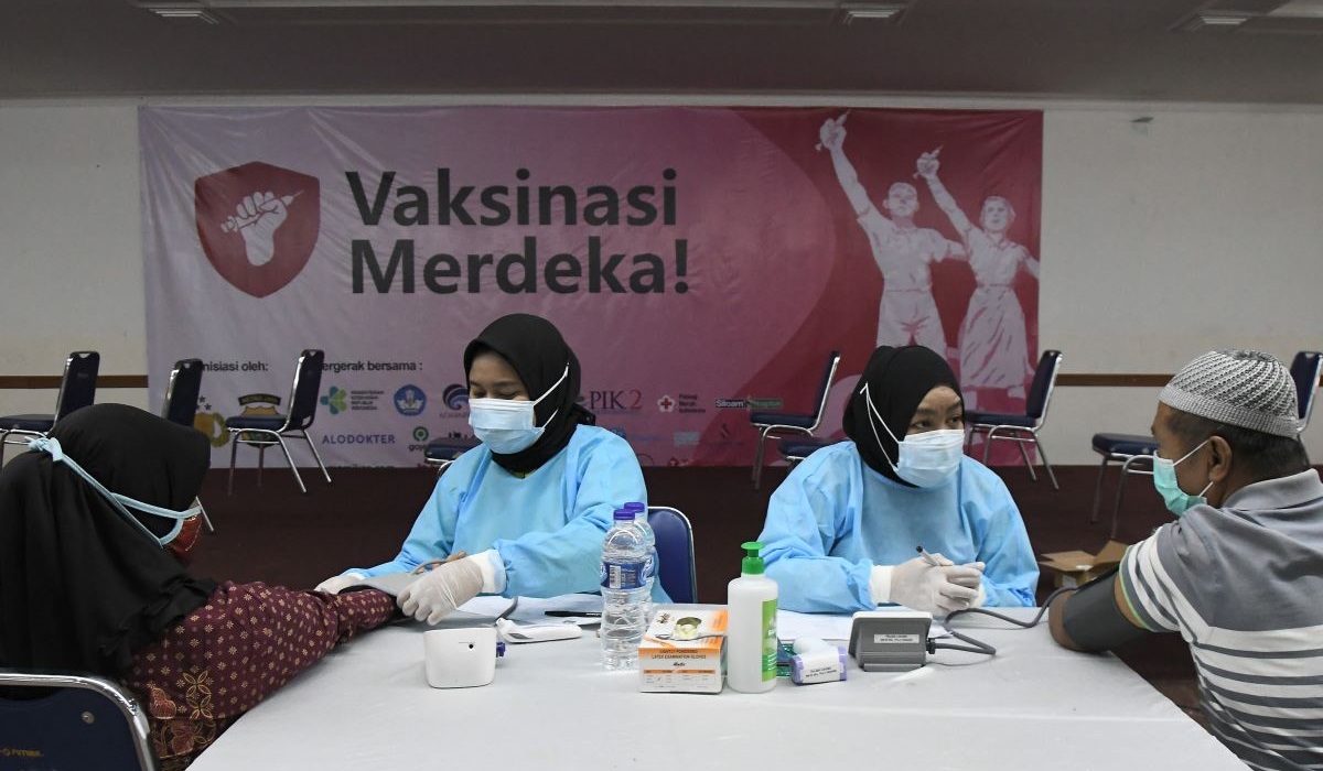 Sejumlah petugas medis mengukur tekanan darah warga sebelum mengikuti vaksinasi merdeka di Jakarta Timur.