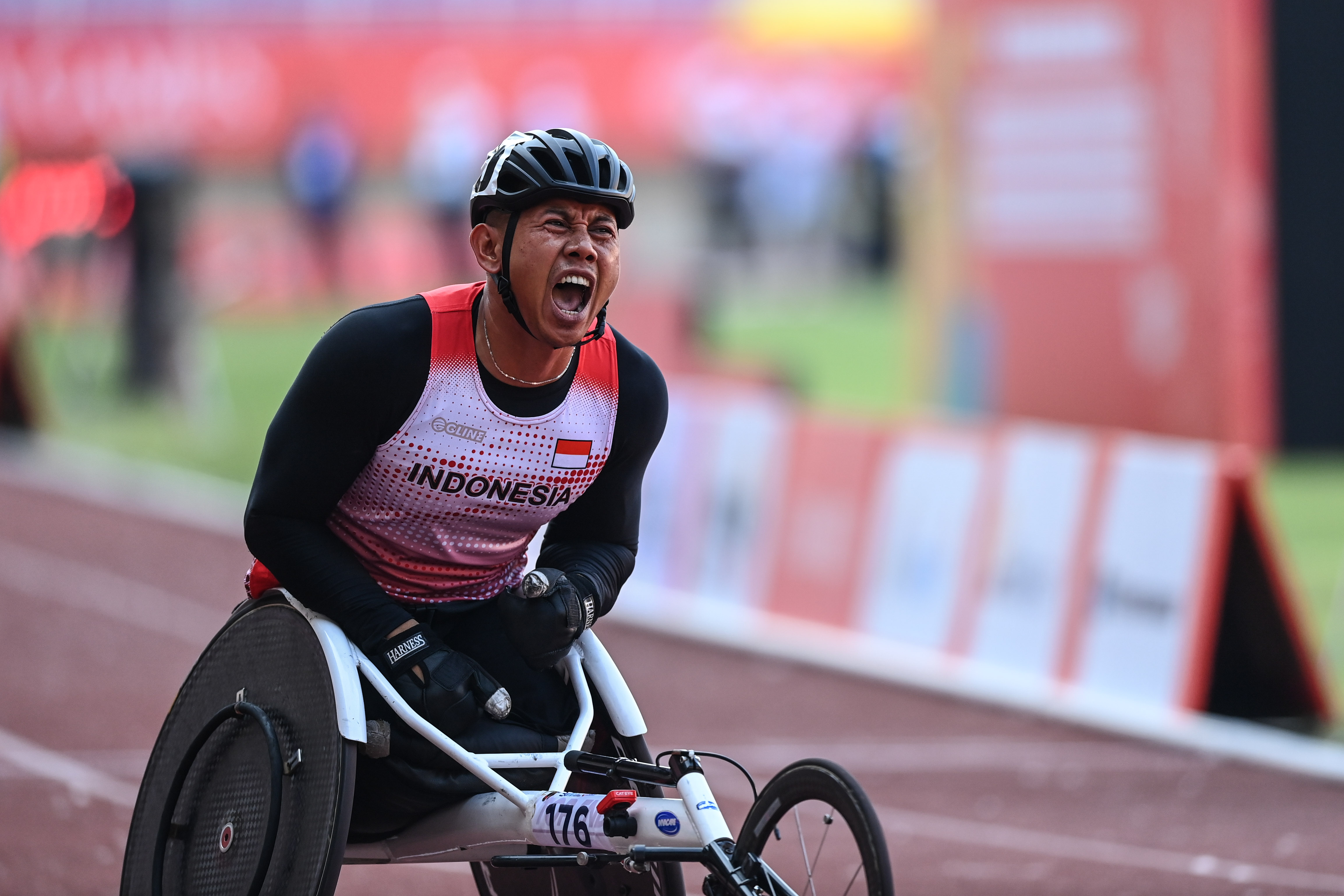Atlet balap kursi roda Jaenal Aripin berteriak usai mengikuti final balap kursi roda 100 meter putra ASEAN Para Games 2022, Senin (1/8).