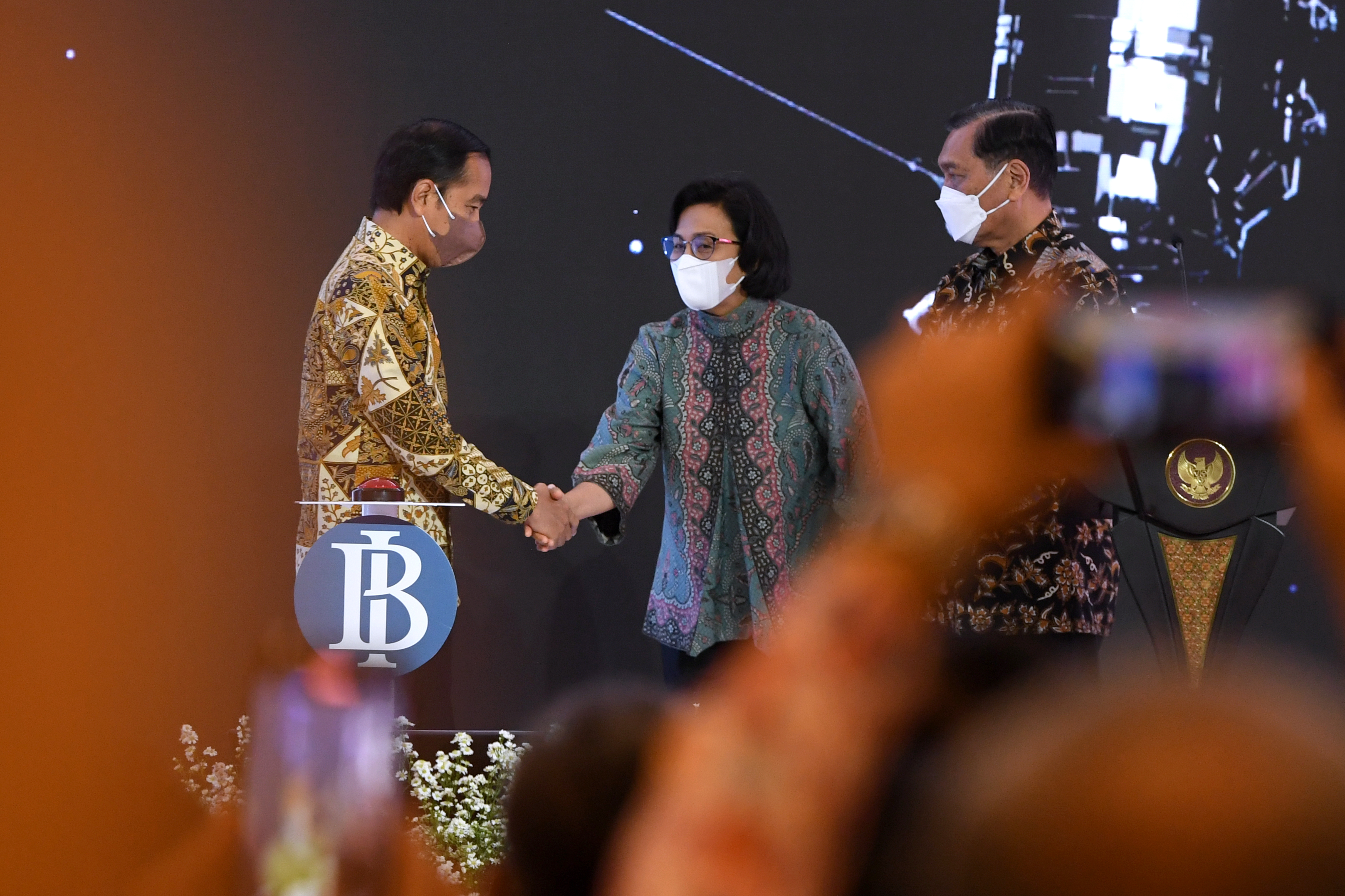 Presiden Jokowi berjabat dengan Menkeu Sri Mulyani dalam suatu forum.