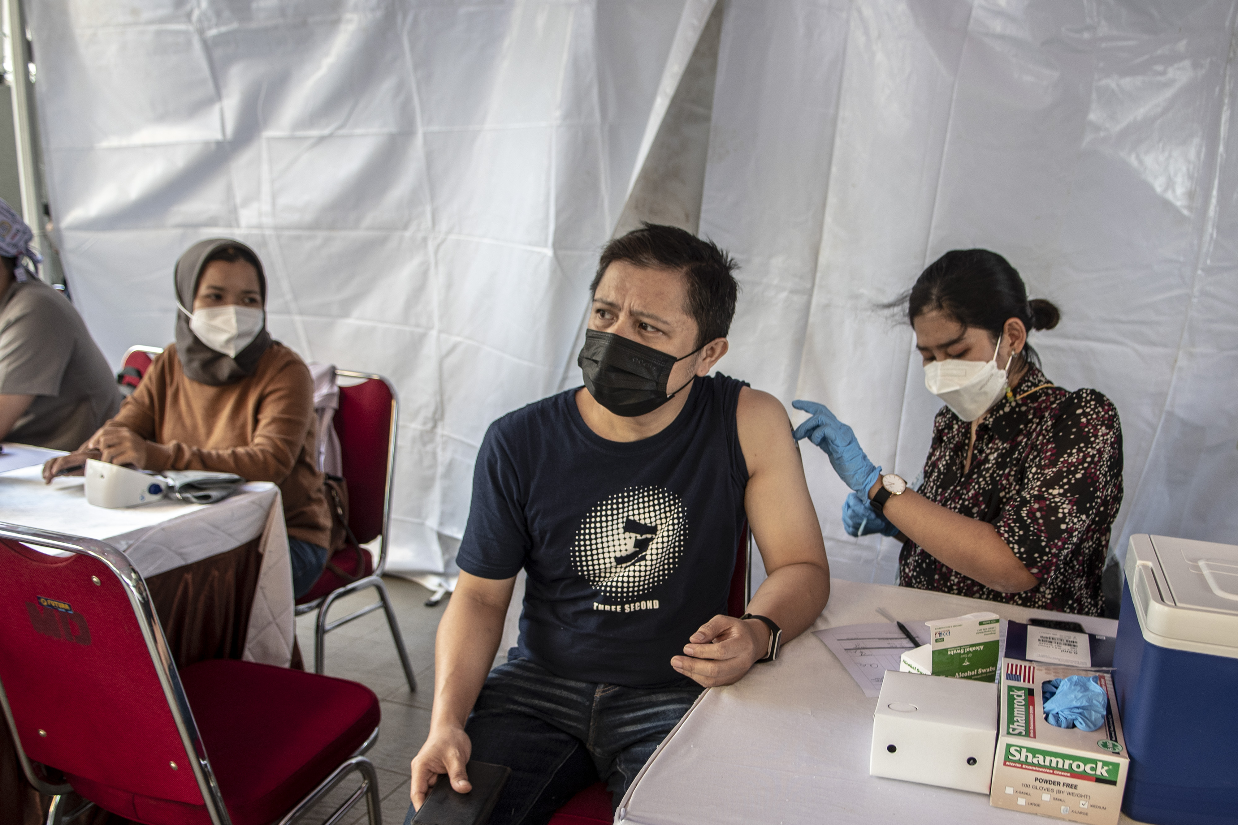  Petugas kesehatan menyuntikkan vaksin booster Covid-19 ke penerima vaksin di kawasan Blok M, Jakarta, Minggu (14/8).