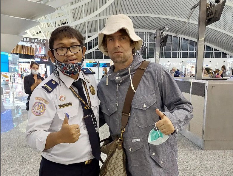 Liam Gallagher (kanan) berfoto dengan penggemarnya saat tiba di Bali.