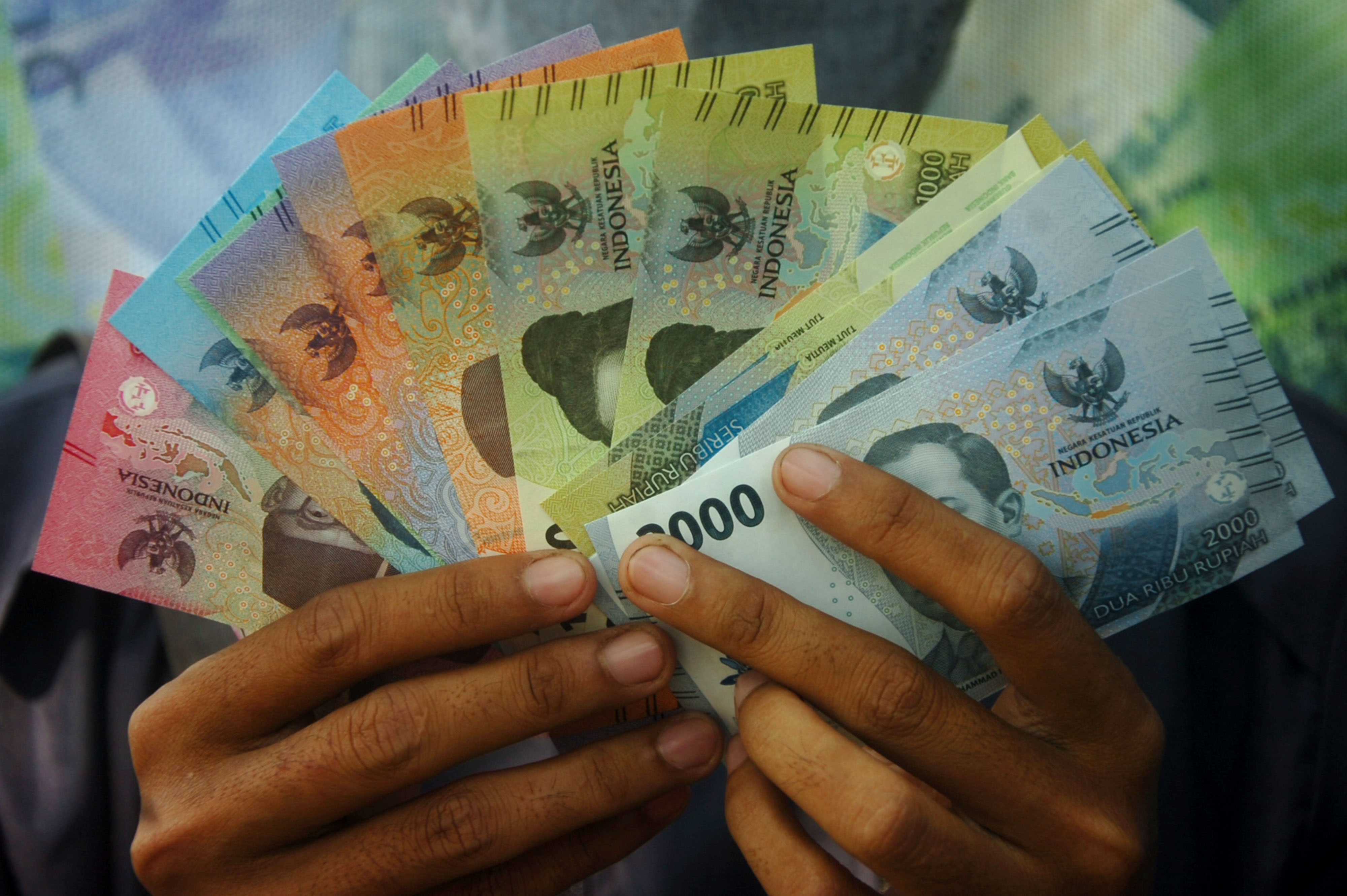 Warga menunjukkan uang kertas baru tahun emisi 2022.