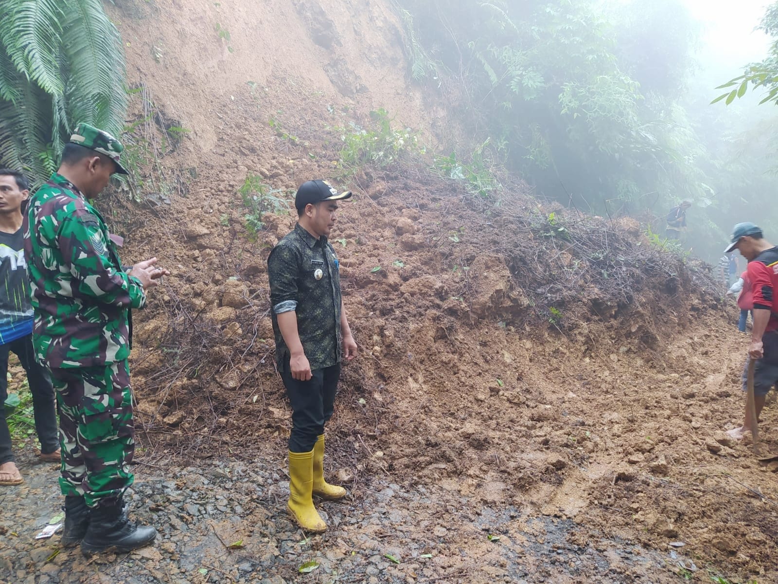 Petugas dari BPBD, TNI, Polri, dibantu warga sedang membersihkan material longsor di Kecamatan Sodonghilir, Tasikmalaya, Kamis (11/8).