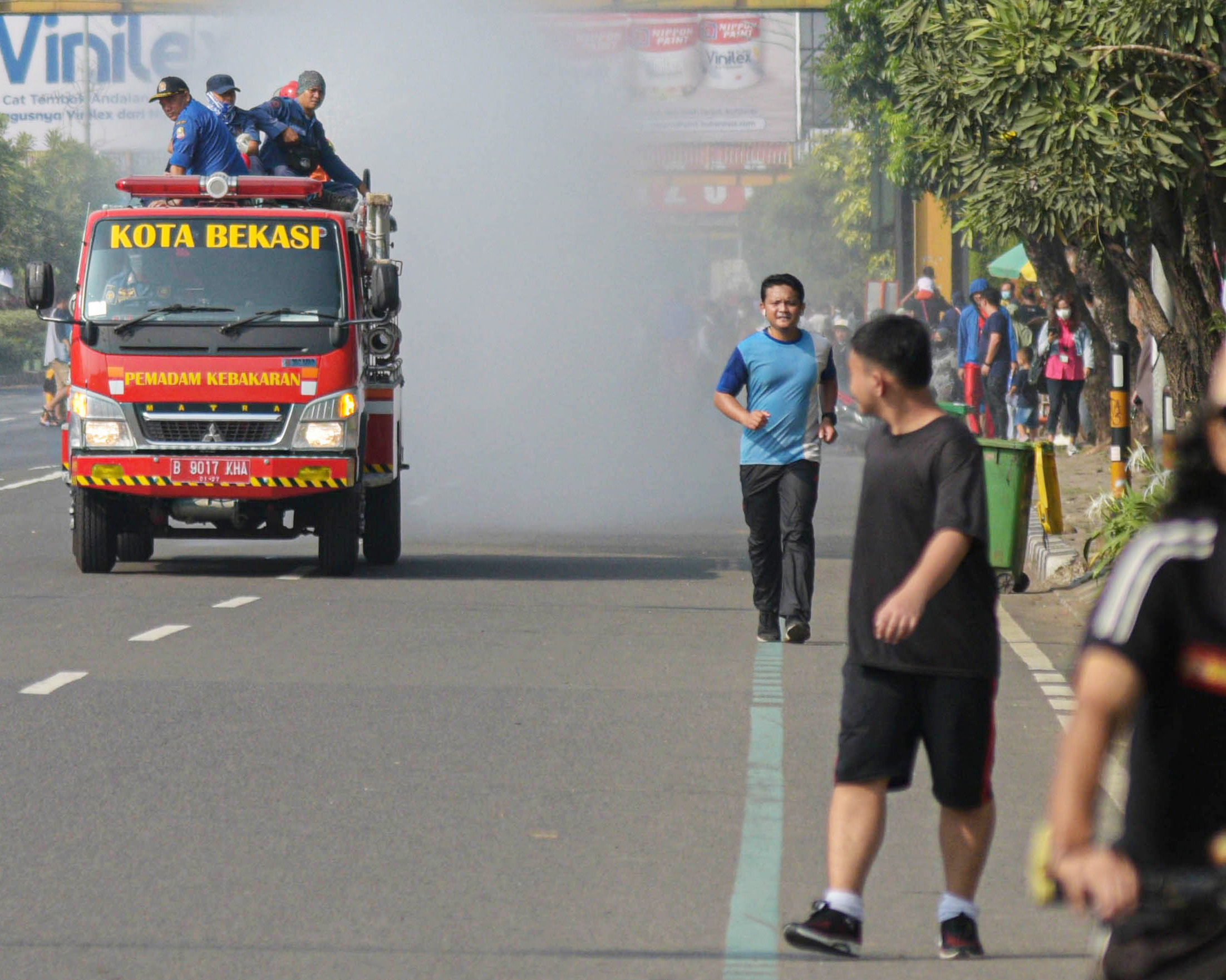 Petugas damkar Kota Bekasi melakukan penyemprotan disinfektan setelah hari bebas kendaraan di Jalan Ahmad Yani, Minggu (22/7).