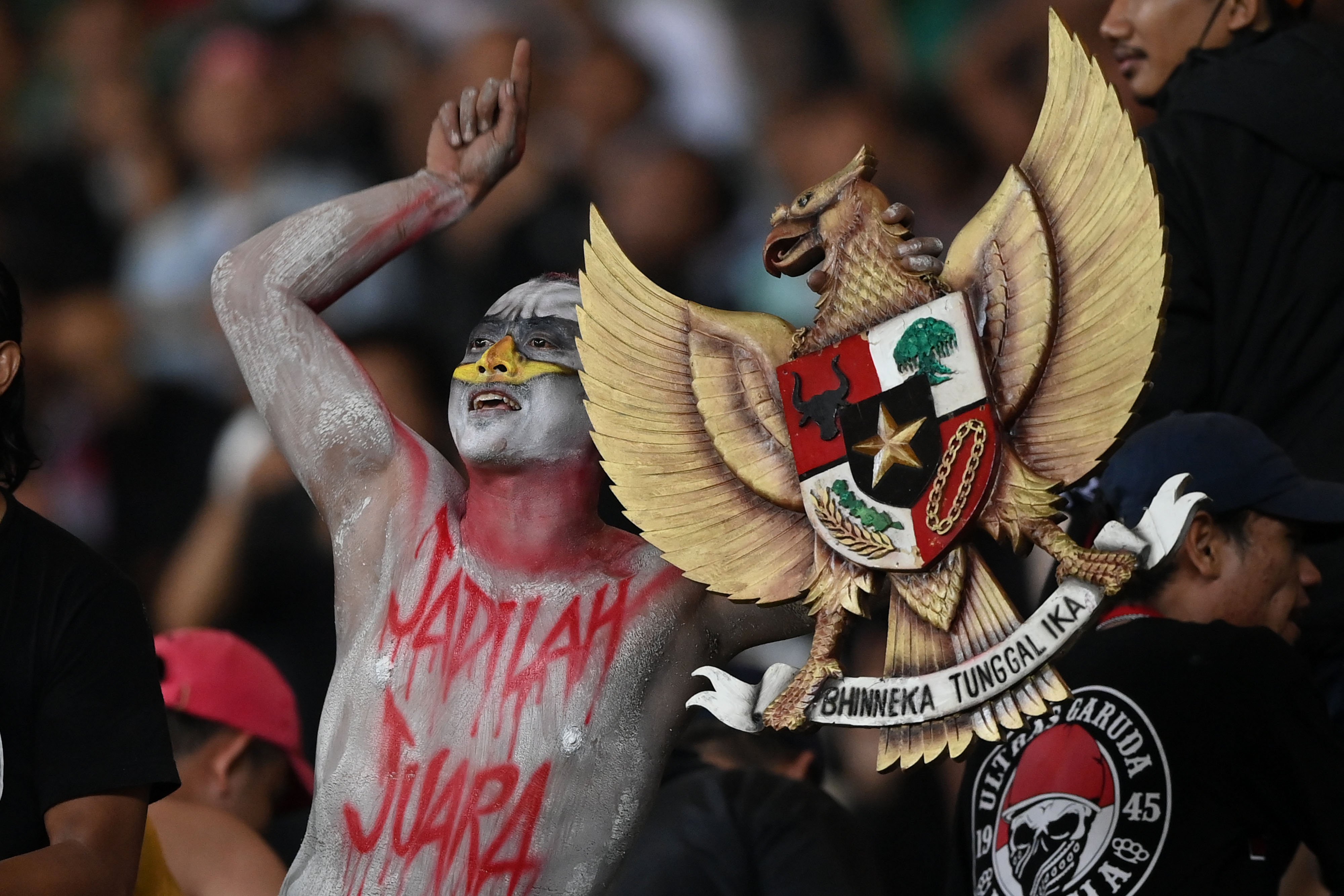 Seorang suporter membawa lambang Garuda Pancasila saat memberikan dukungan untuk Tim Nasional Indonesia.