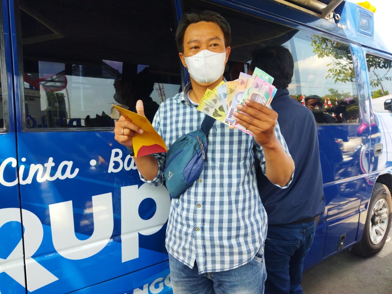 Warga memperlihatkan uang baru