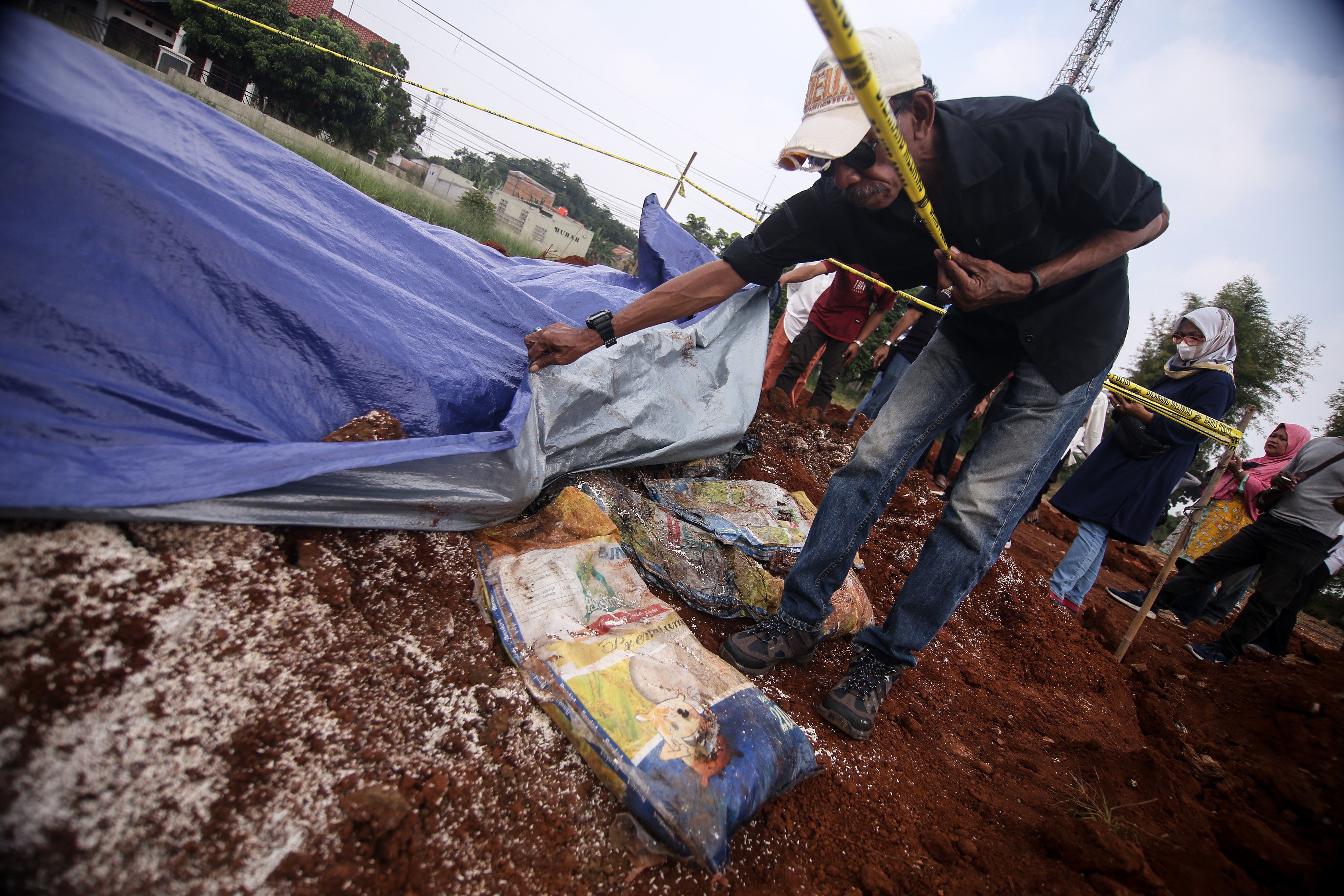 Warga melihat penemuan barang diduga bansos presiden di Kawasan Kampung Serab, Sukmajaya, Depok, Jawa Barat.