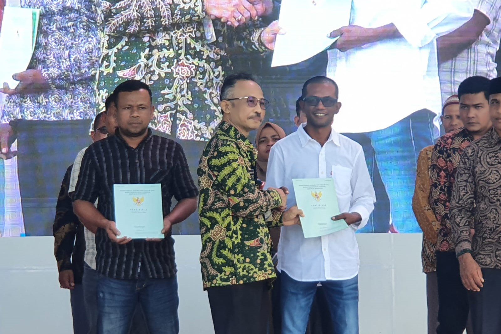 Kepala BSKDN menyerahkan sertipikat tanah secara simbolis kepada mantan narapidana politik atau korban konflik Gerakan Aceh Merdeka.