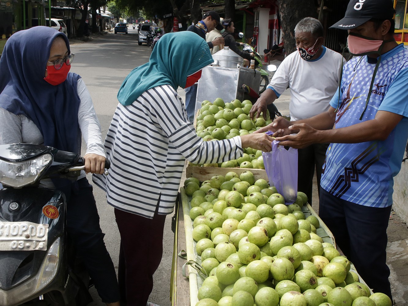 Pedagang melayani warga membeli jambu biji merah di Jalan Merdeka, Sukmajaya, Depok, Jawa Barat.