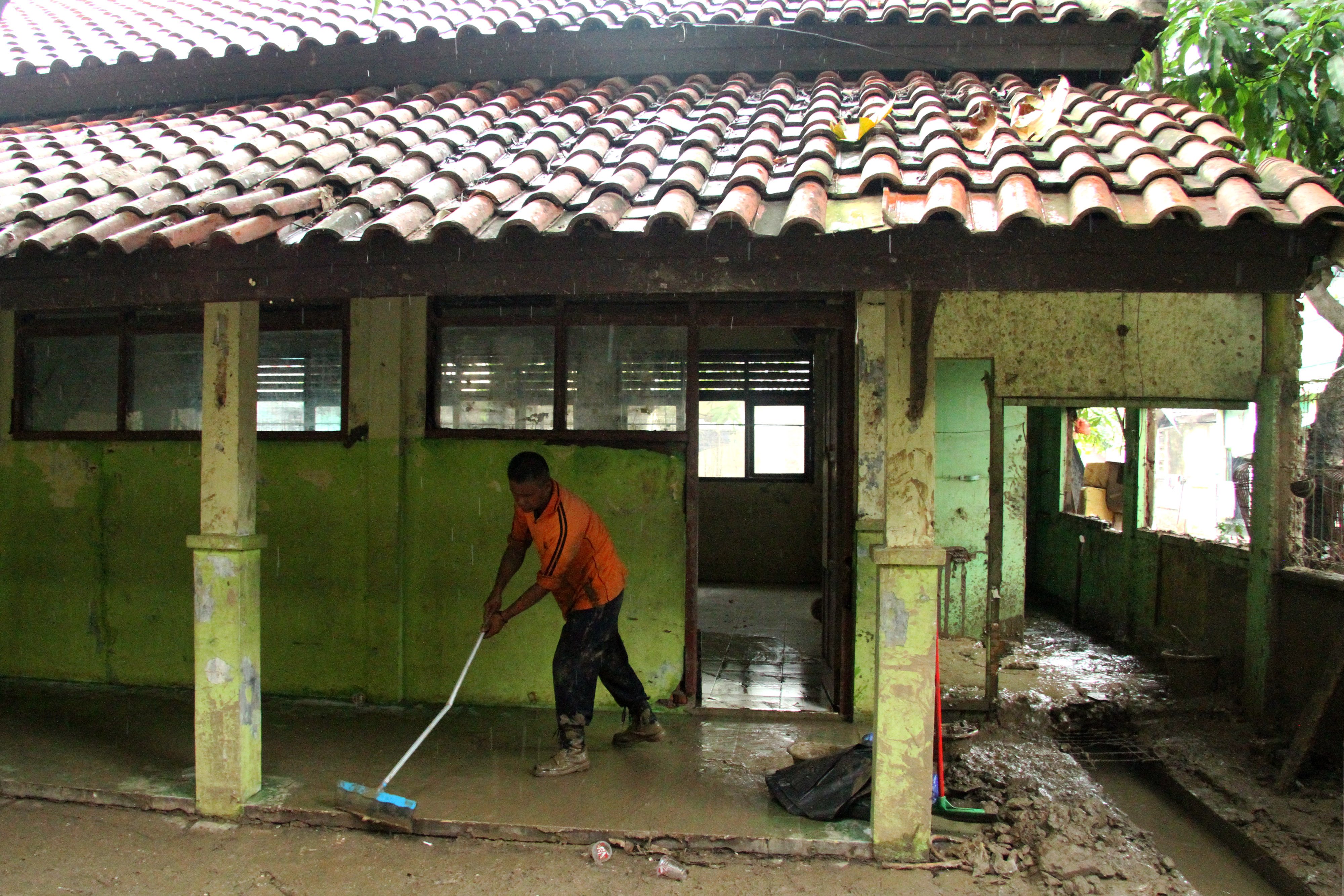 Petugas membersihkan ruang kelas yang rusak dan kotor akibat banjir di SDN Jatirasa 5, Bekasi, Jawa Barat, Kamis (9/1/2020).