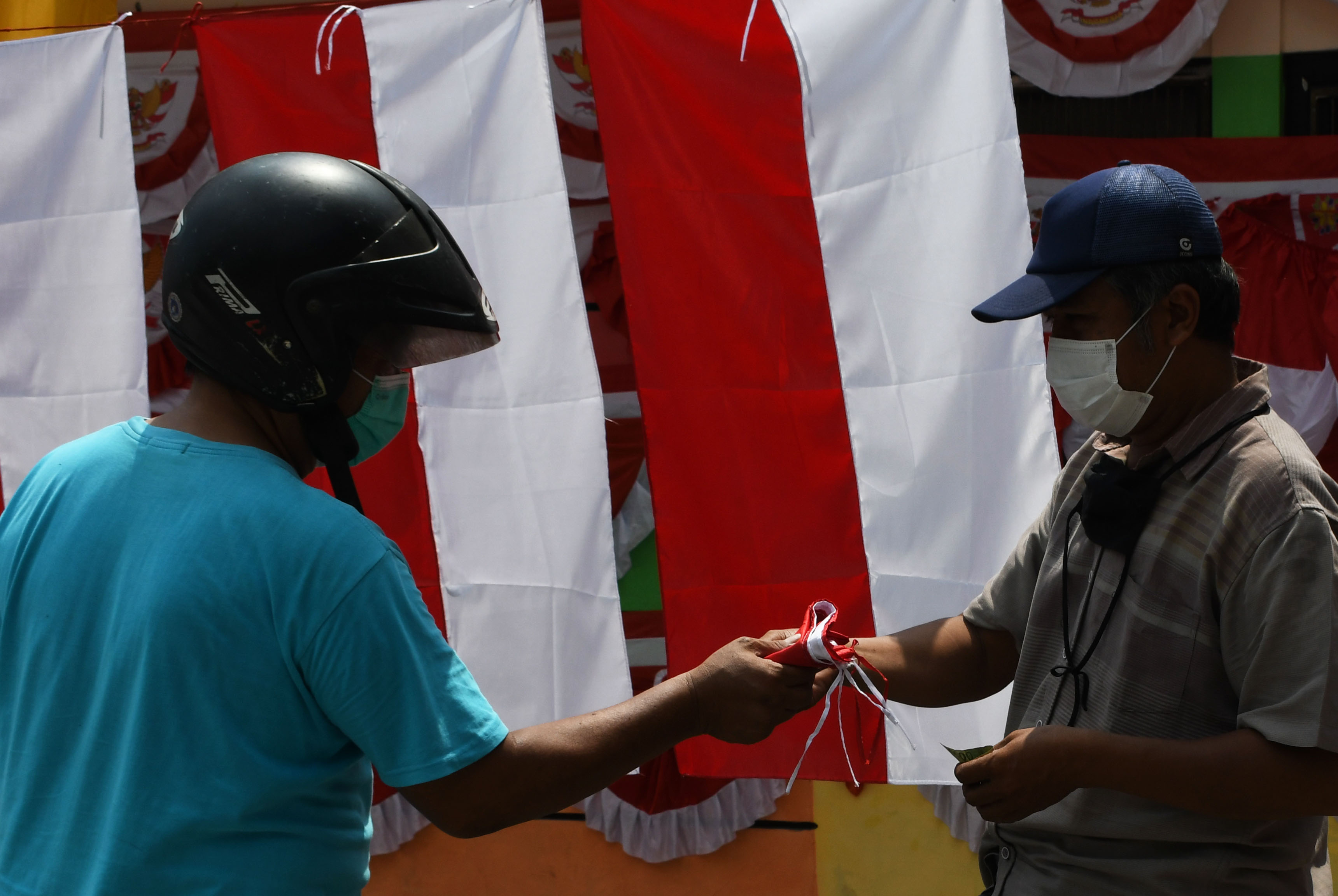 Pedagang musiman bendera merah putih melayani pembeli