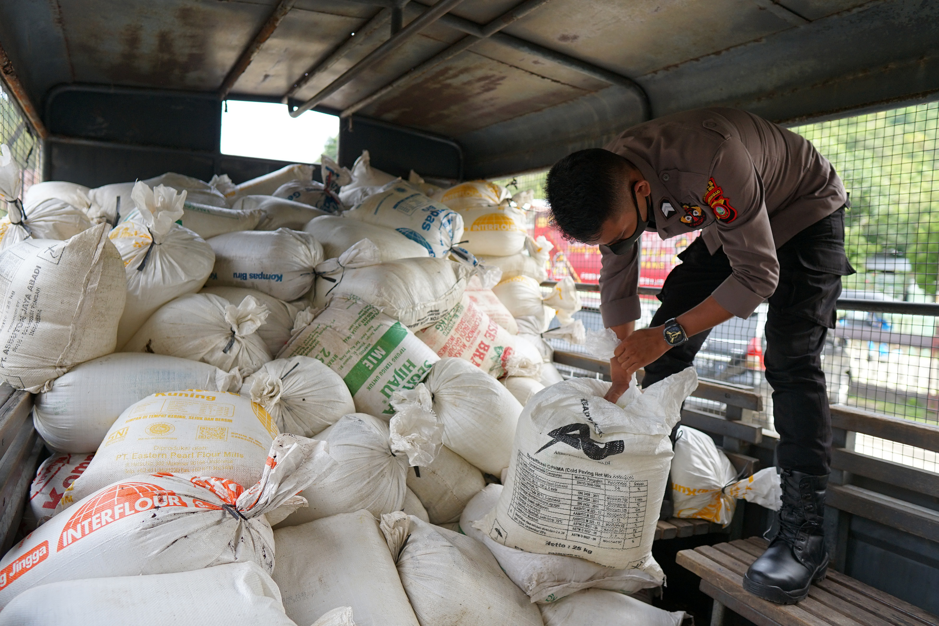 Anggota Polri menunjukkan minuman keras (miras) yang dibungkus kantong plastik dalam karung di Polres Gorontalo Kota, Gorontalo, Sulawesi Ut