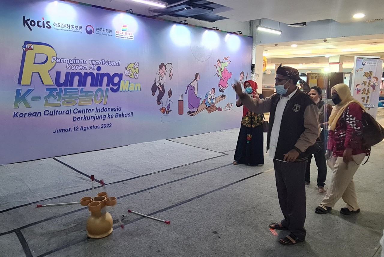 Seorang warga memainkan permainan tradisional Korea dalam acara yang diadakan KCCI di Bekasi.