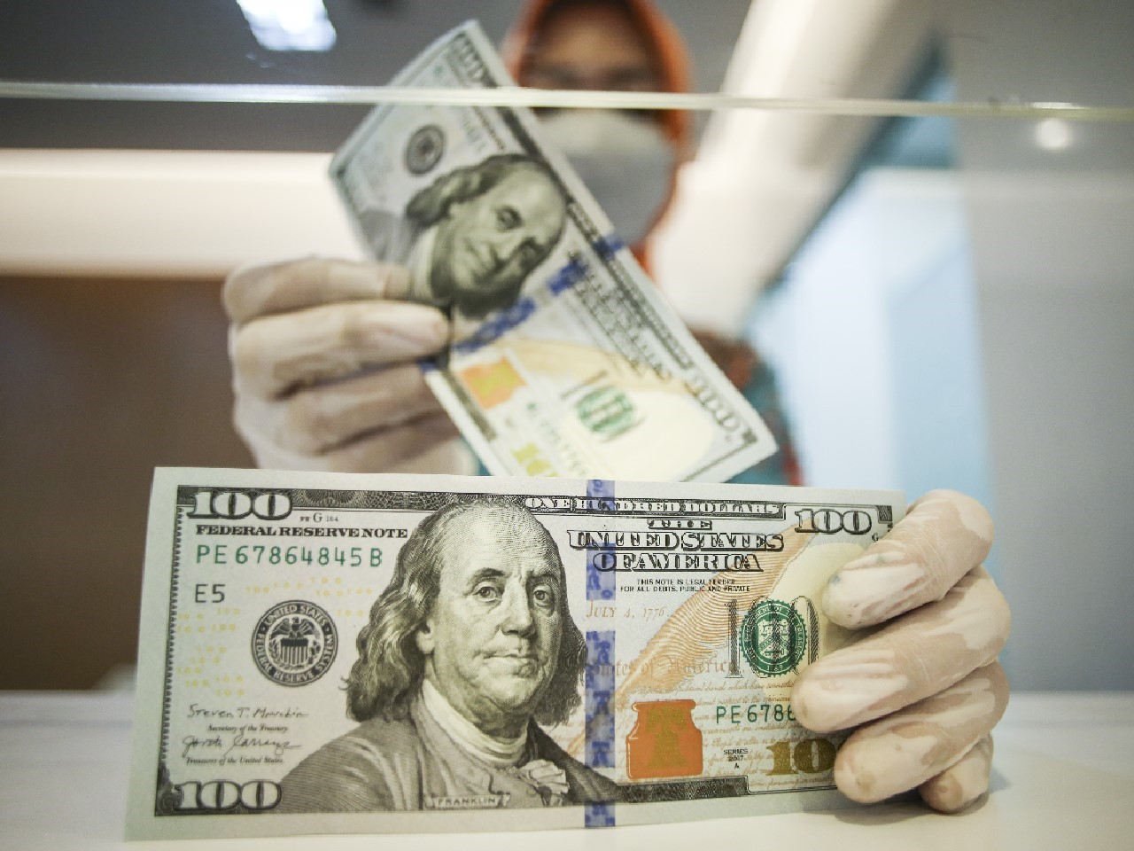 Petugas menghitung uang dolar AS di BNI KC Mega Kuningan, Jakarta, kemarin. 