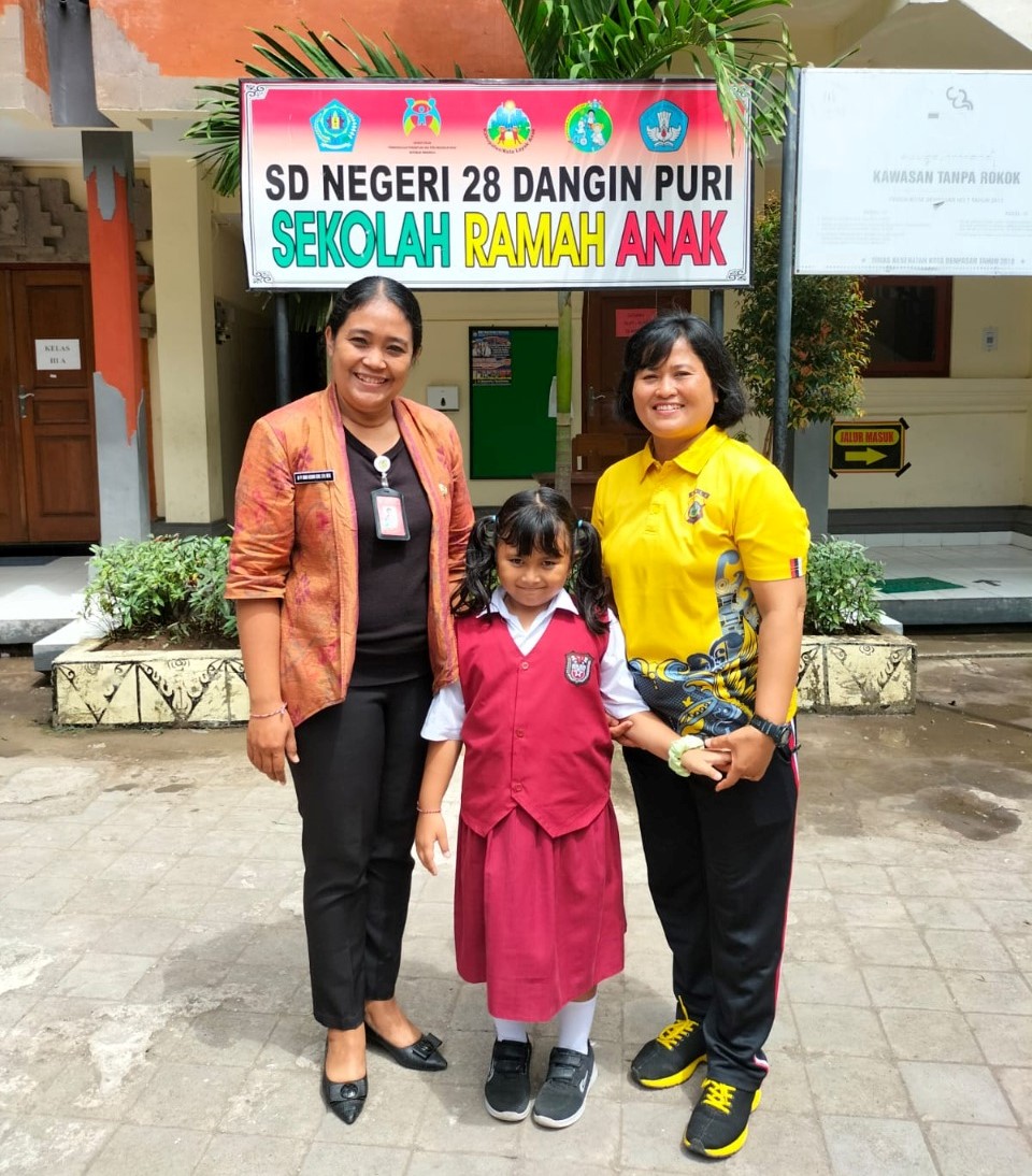 Siswi Ni Komang Ayu Sri Saraswati diapit oleh Kepala SD 28 Dangin Puri Ni Putu Wiwik Kusuma Dewi (kiri) dan ibunya Aiptu Ni Made Suryani.