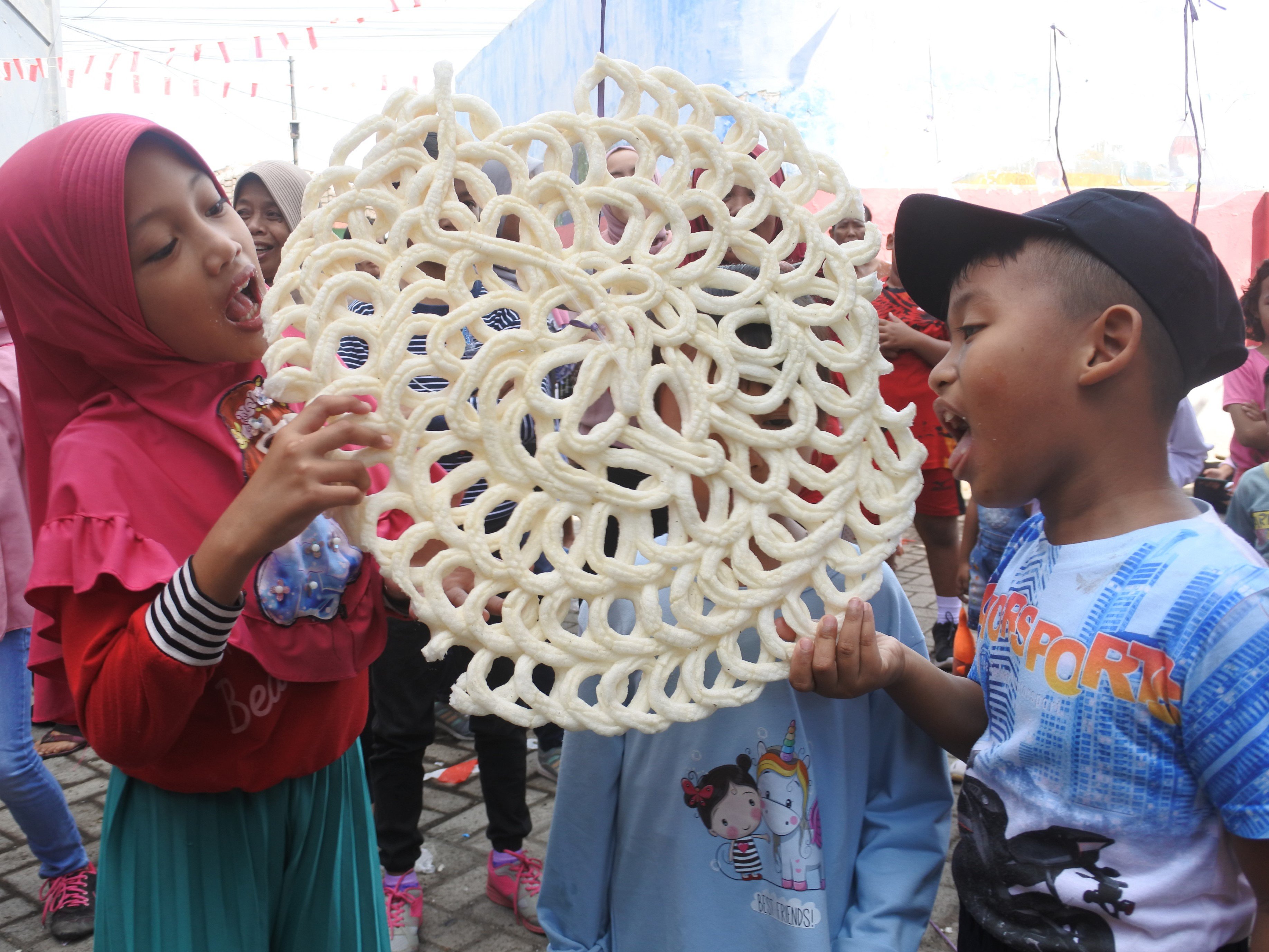 Sejumlah warga mengikuti lomba makan kerupuk di Kelurahan Ardirejo, Panji, Situbondo, Jawa Timur, Minggu (21/8/2022). 