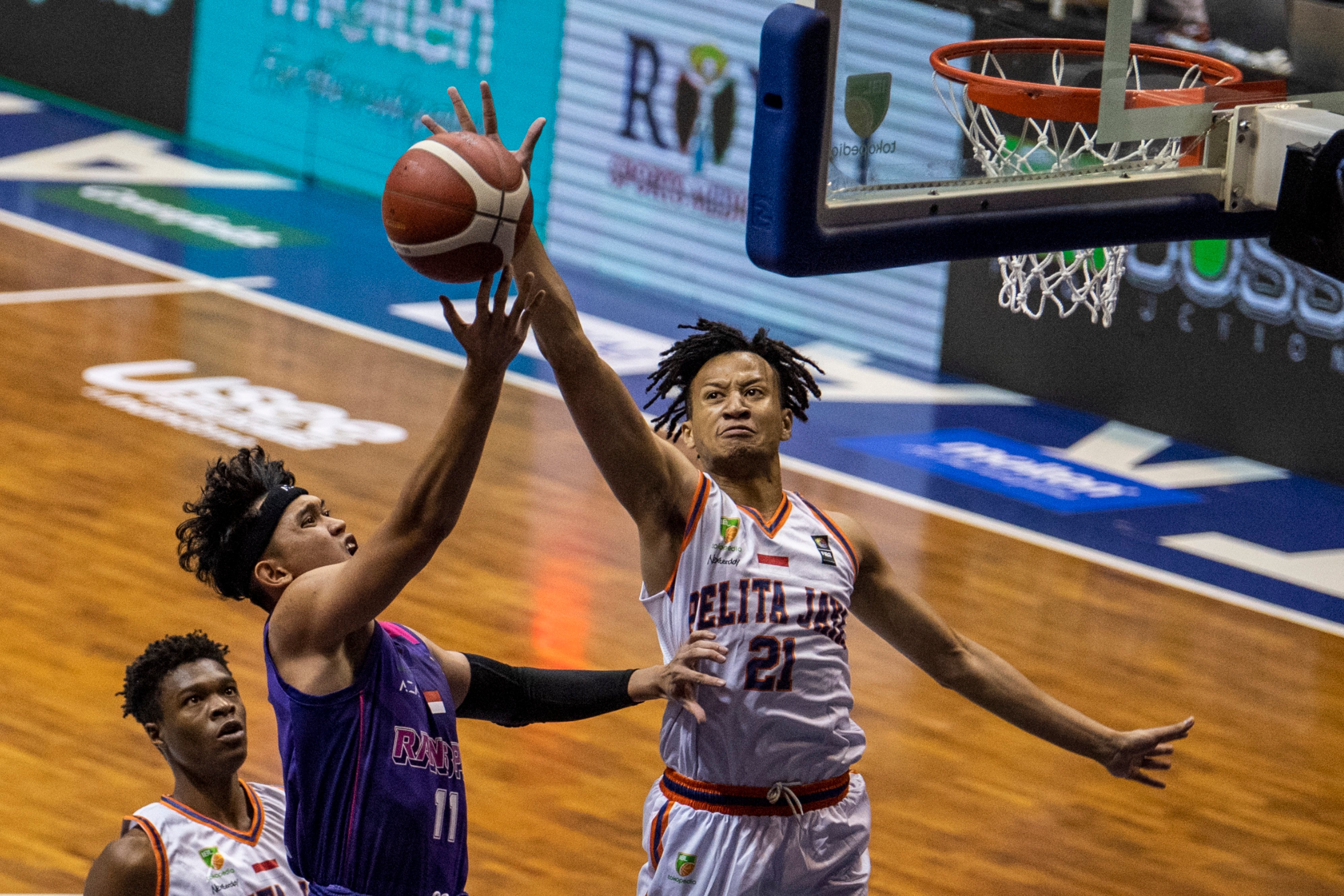 Pebasket Pelita Jaya Bakrie Jakarta Hendrick Xavi Yonga mengeblok layup RANS PIK Althof Dwira Satrio pada laga perdana playoff IBL 2022.