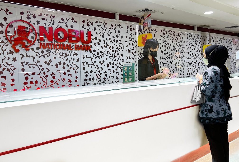 Seorang pegawai Nobu Bank sedang melayani nasabah.