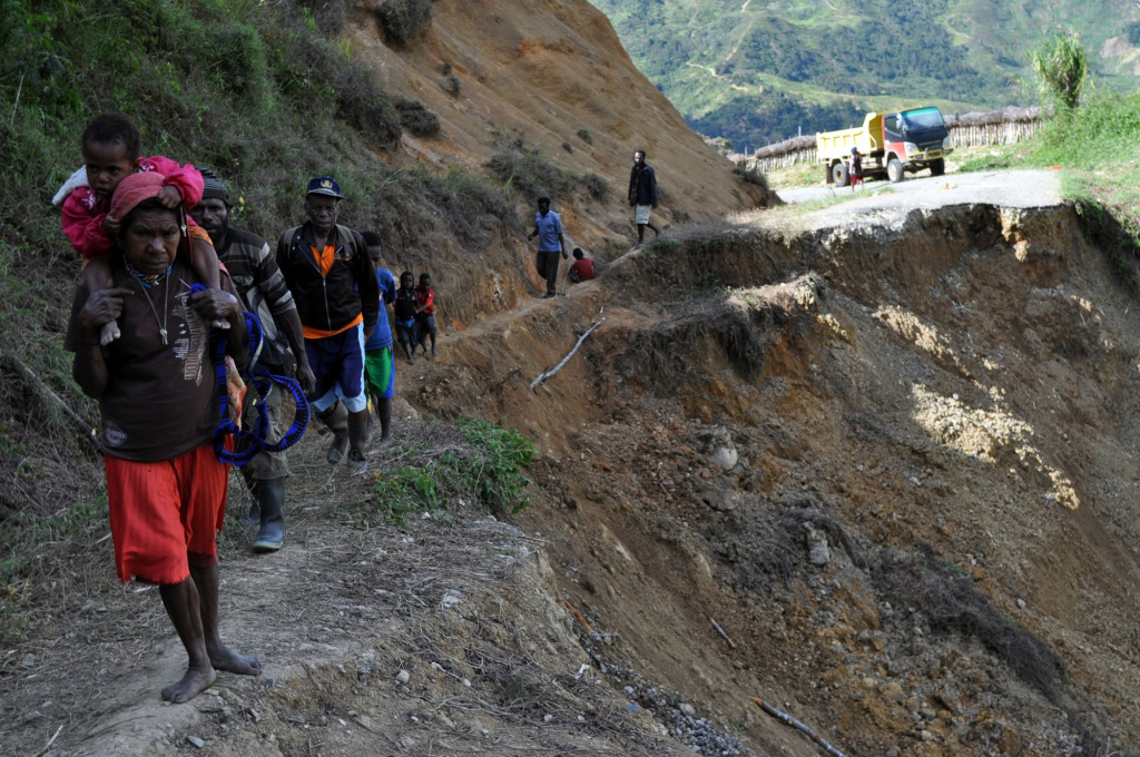 Sejumlah warga melintas ruas jalan yang longsor di poros Wamena-Tiom, Kabupaten Lanny Jaya, Papua, Minggu (22/1/2022).
