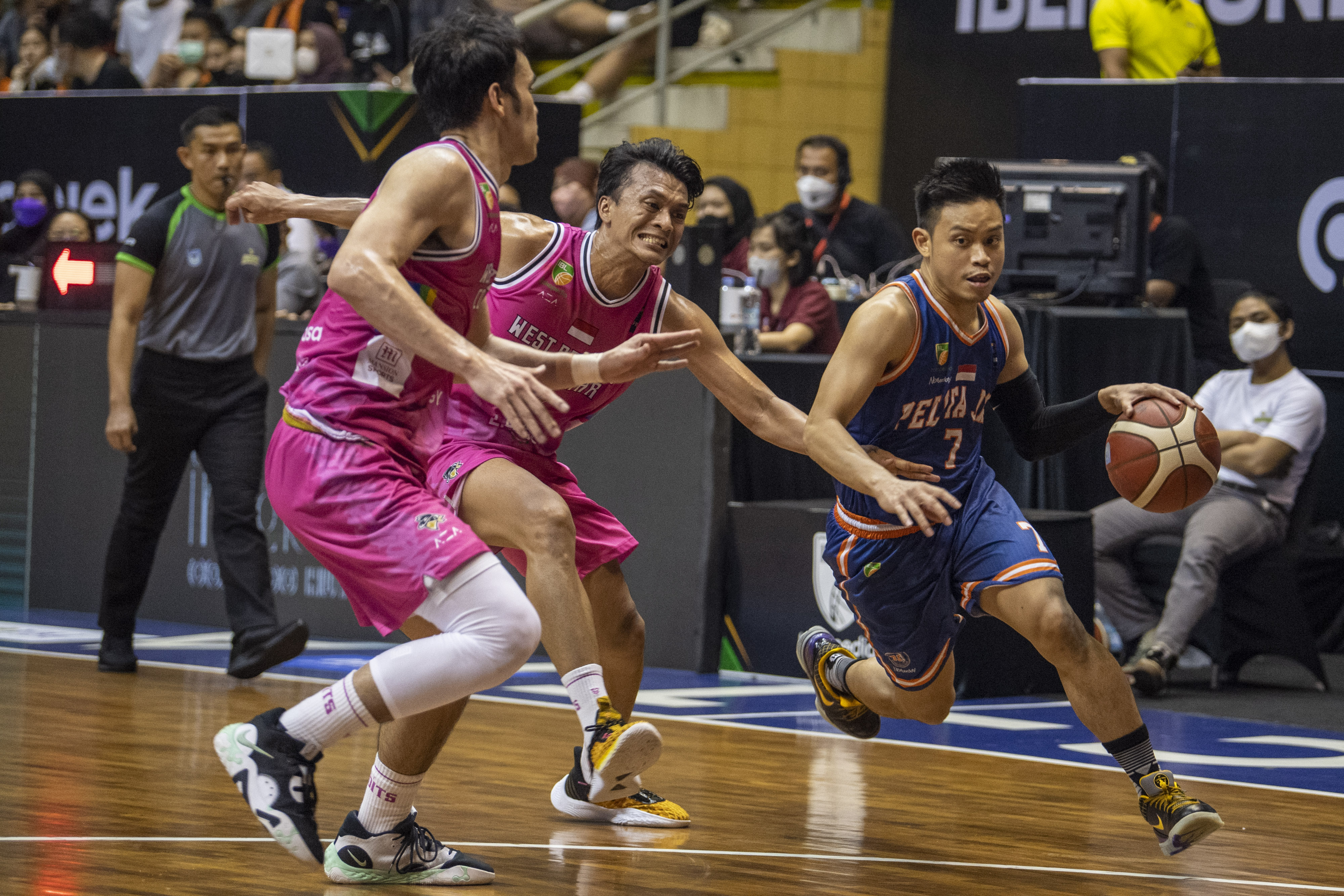 Pebasket Pelita Jaya Andakara Prastawa Dhyaksa (kanan) berusaha melewati dua pemain West Bandits Combiphar Solo, Minggu (21/8).