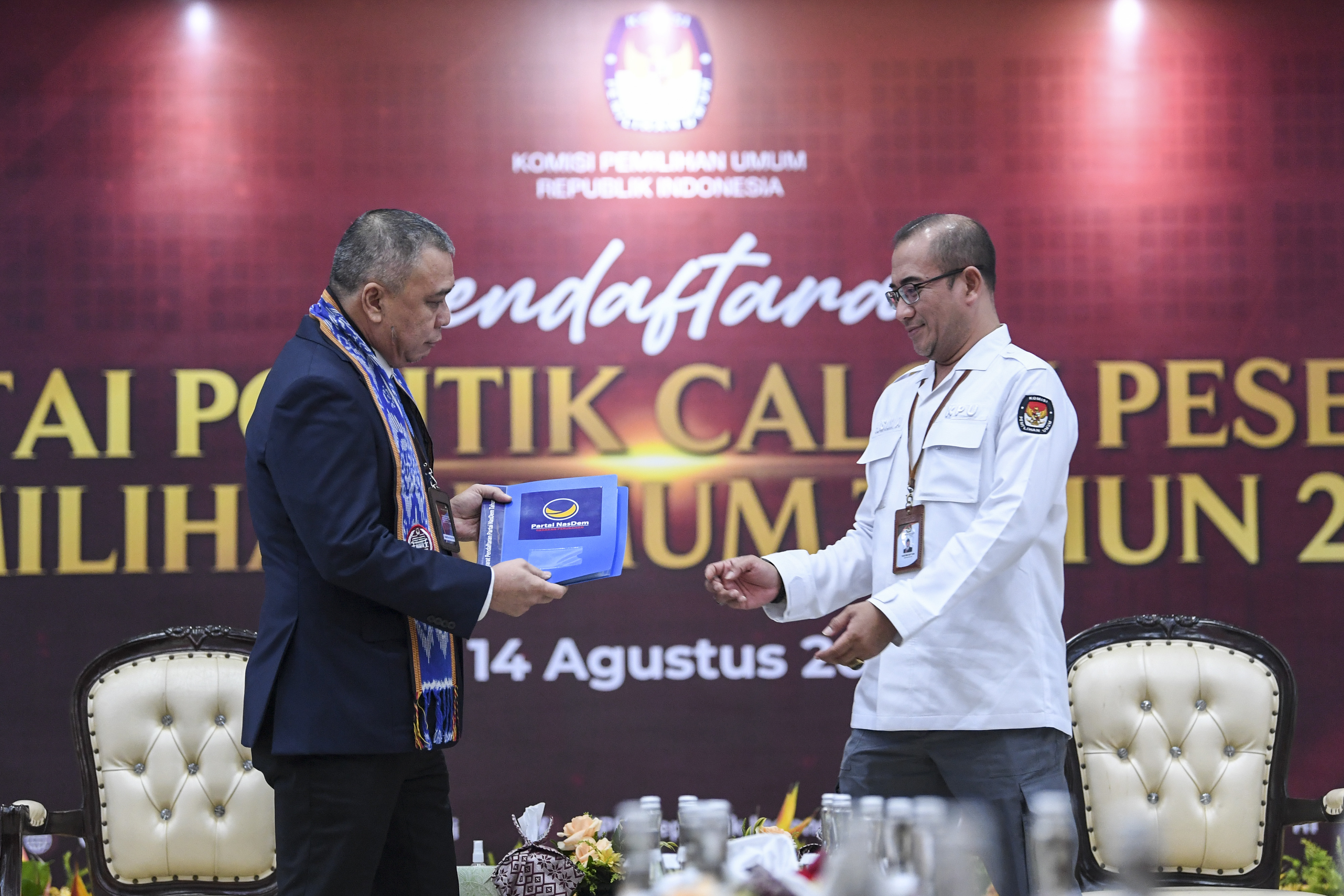 Ketua KPU Hasyim Asy'ari (kanan) bersiap menerima berkas pendaftaran dari Wakil Ketua Umum Partai NasDem Ahmad Ali.