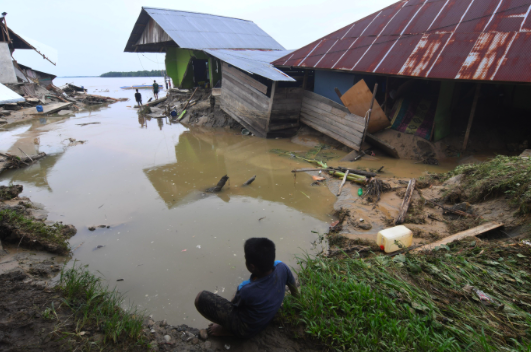 Warga berada di sekitar rumah yang rusak akibat diterjang banjir bandang di Desa Torue, Kab Parigi Moutong, Sulawesi Tengah, Jumat (29/7).