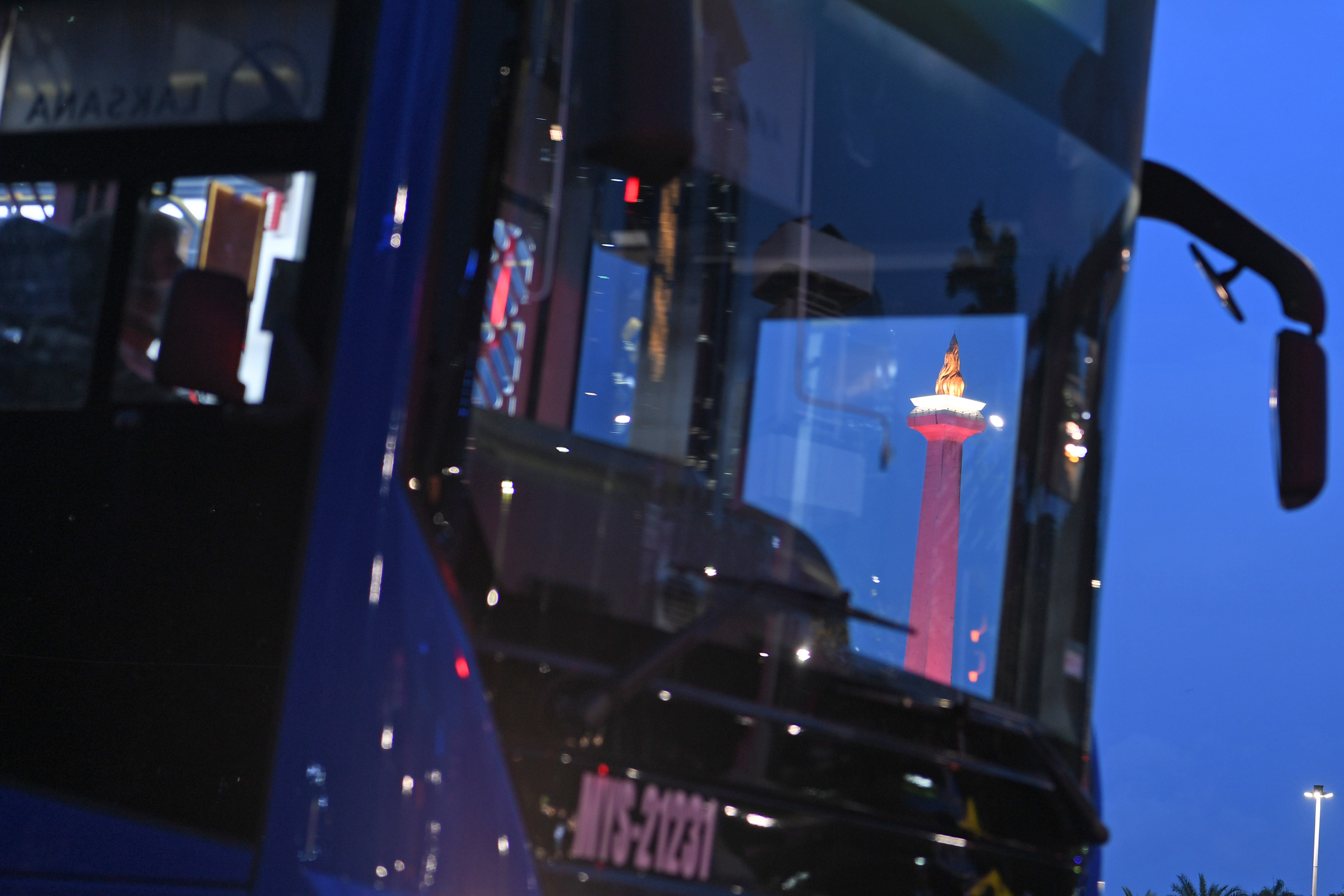 Bus TransJakarta beroperasi malam hari di sekitar kawasan Monas, Jakarta Pusat.