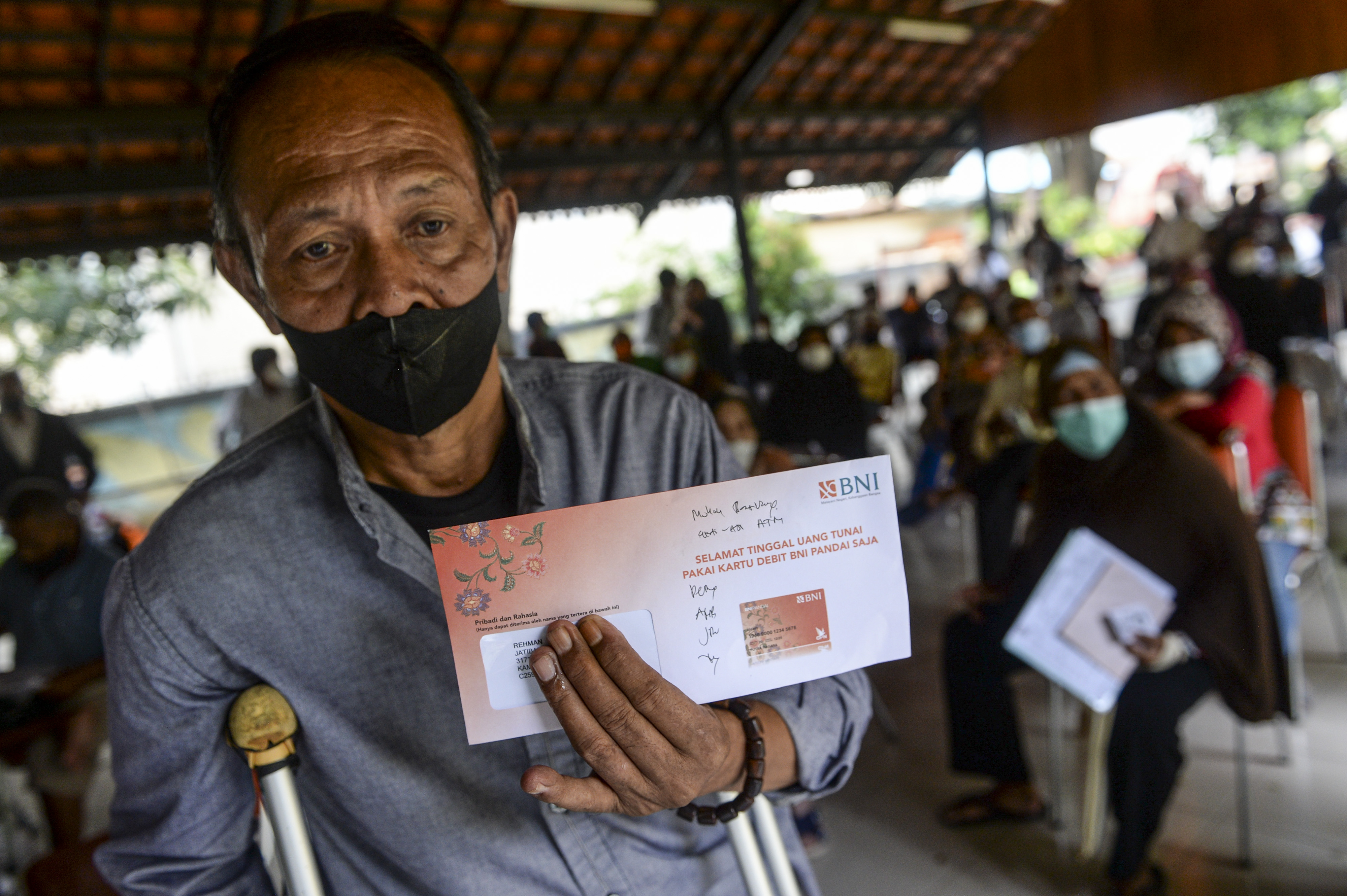 Seorang lansia menerima bantuan sosial