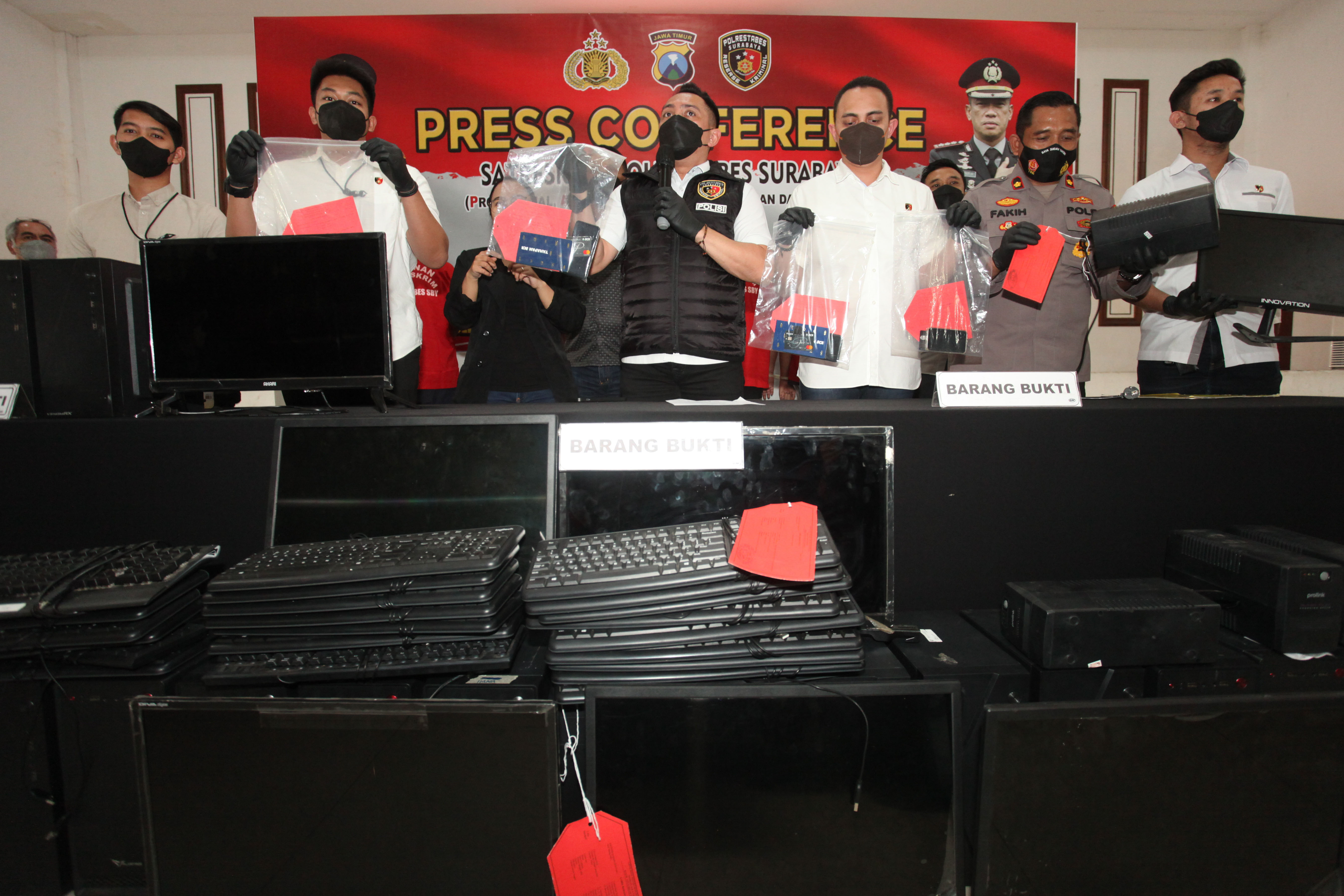 Polisi menunjukkan barang bukti kasus perjudian daring saat rilis di Polrestabes Surabaya, Jawa Timur, Sabtu (20/8).