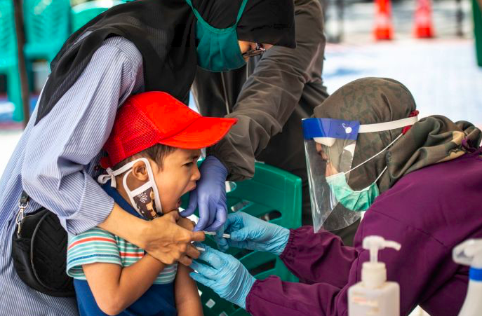 Dokter puskesmas menyuntikkan vaksin MR kepada seorang anak di Jakarta.