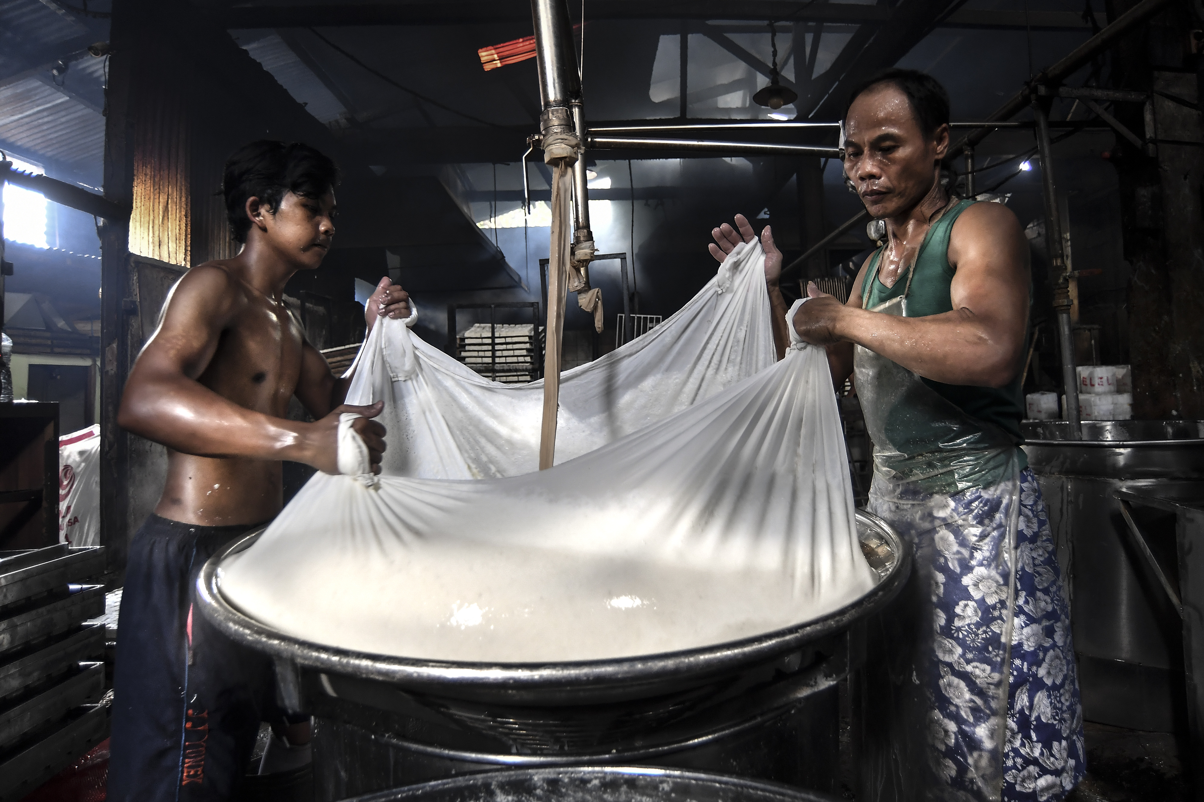 Pekerja memproduksi tahu di industri rumahan wilayah Jakarta.