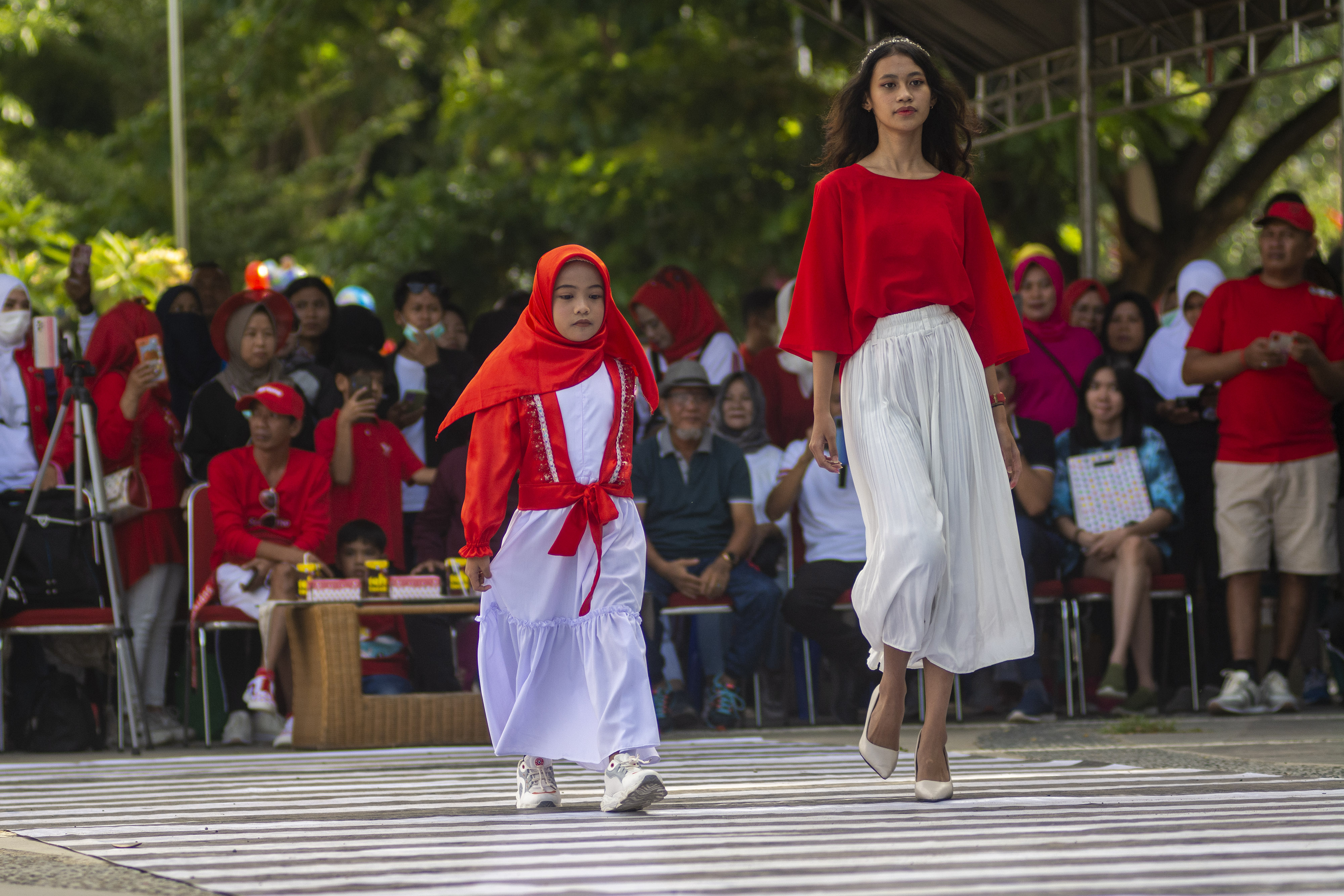 Peserta mengikuti peragaan busana jalanan (fashion street) bertema kemerdekaan di Palu, Sulawesi Tengah, Minggu (14/8).