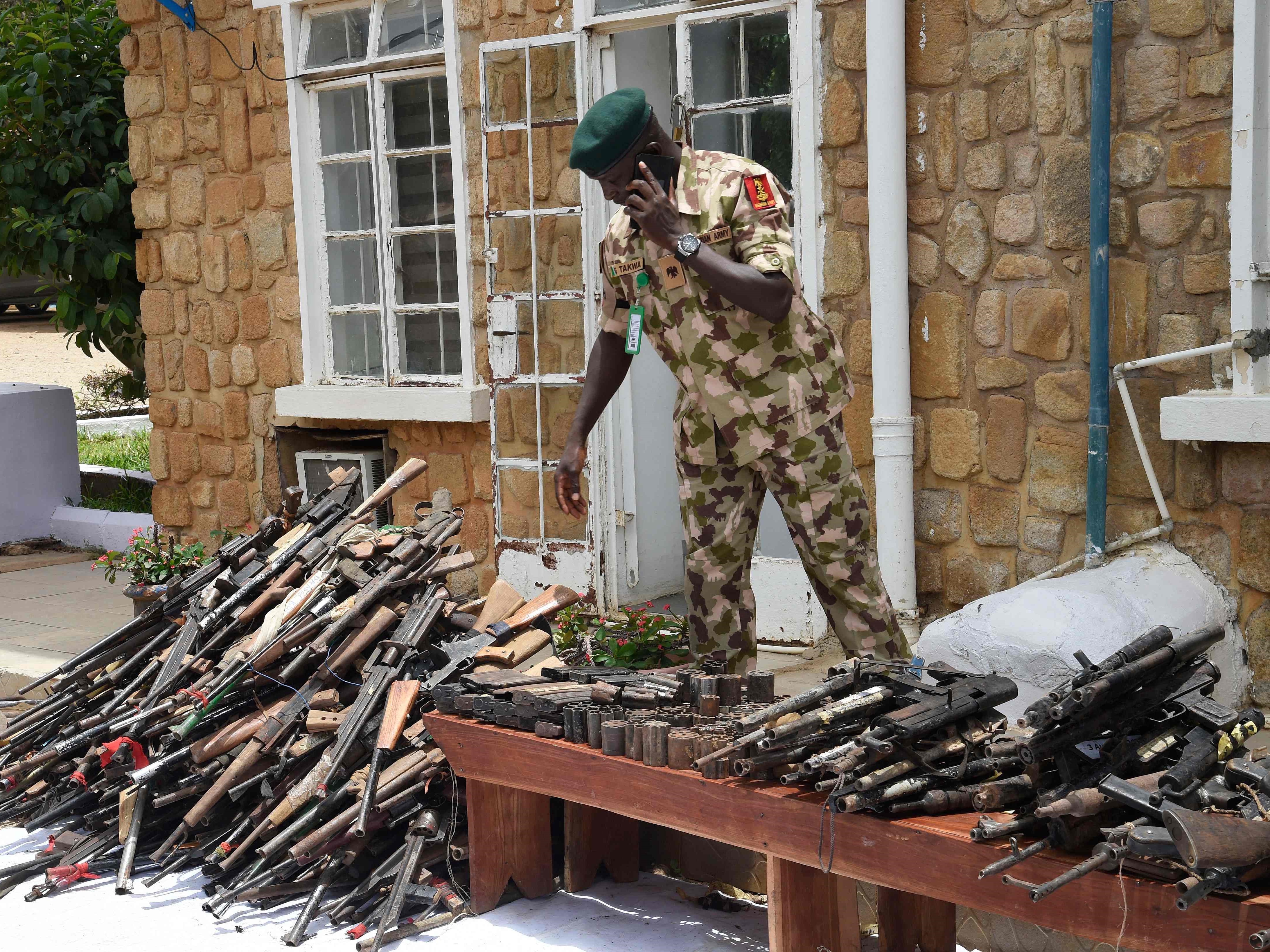 Seorang tentara Nigeria terlihat pada 21 April 2022 di tengah senjata ringan dan senjata ringan yang ditemukan dari bandit.