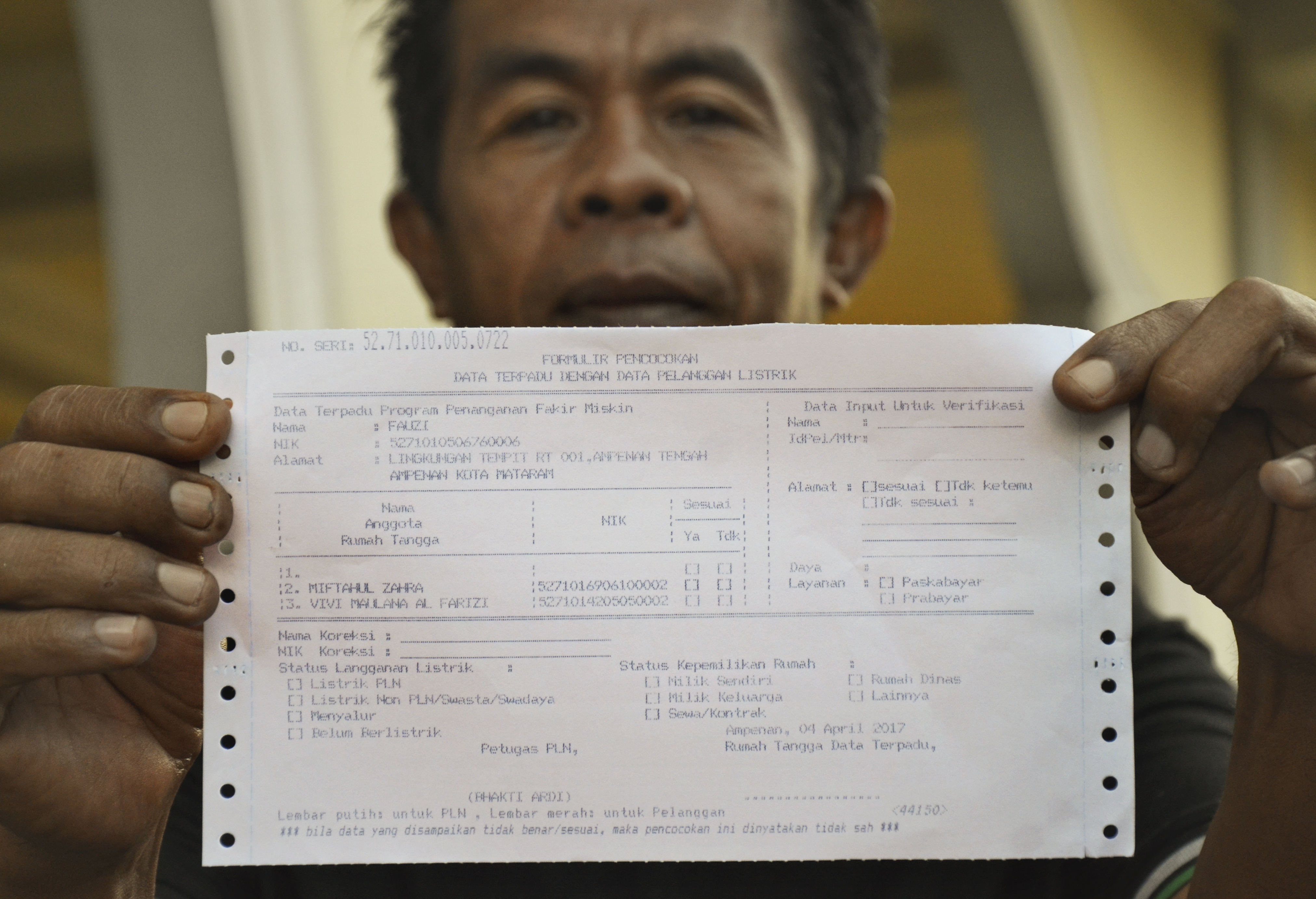 Pelanggan menunjukkan tanda terima pembayaran listrik