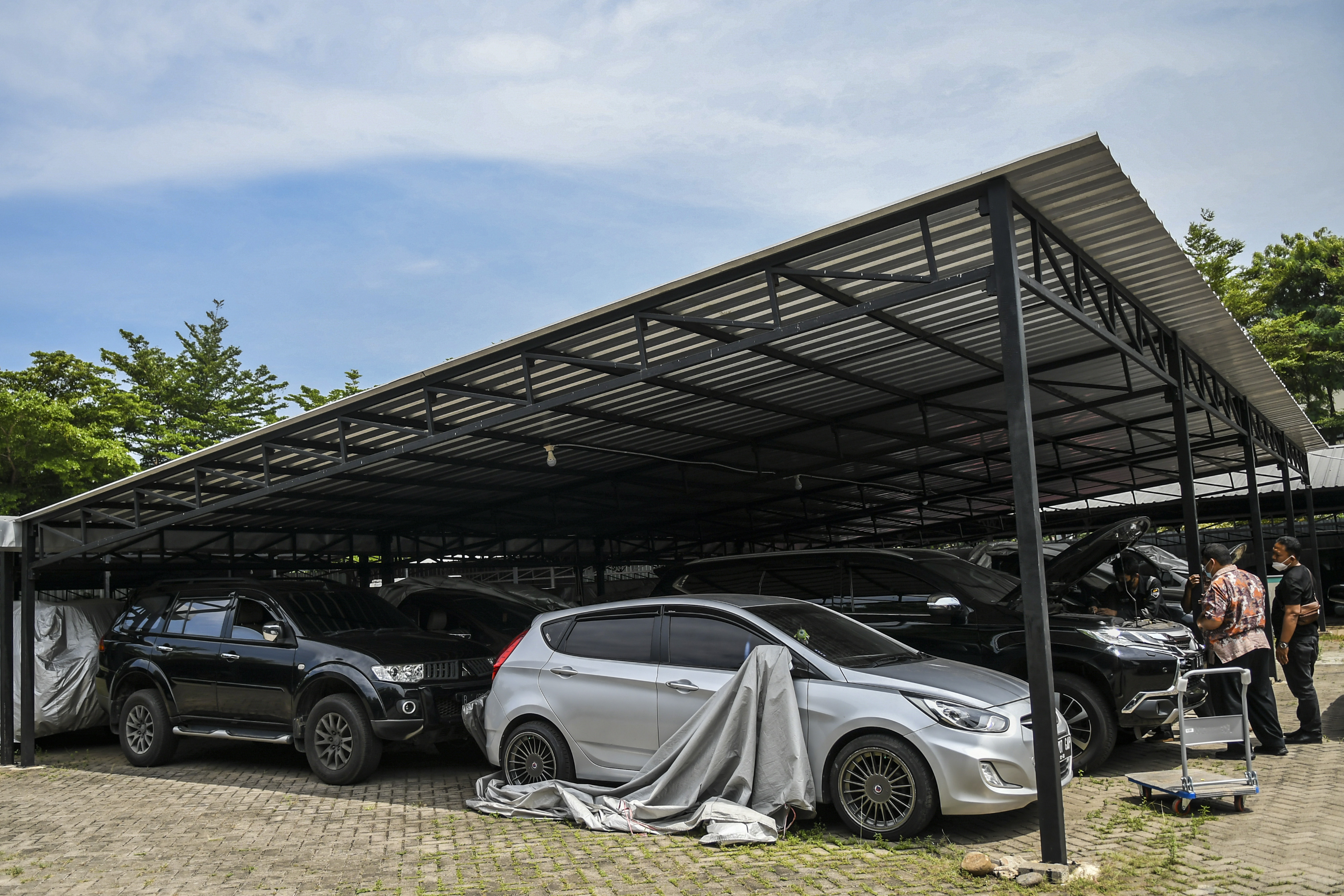 Ilustrasi. Pekerja membersihkan mobil yang digadaikan di gudang penyimpanan kendaraan Kantor Pegadaian di Kebon Nanas, Jakarta Timur.