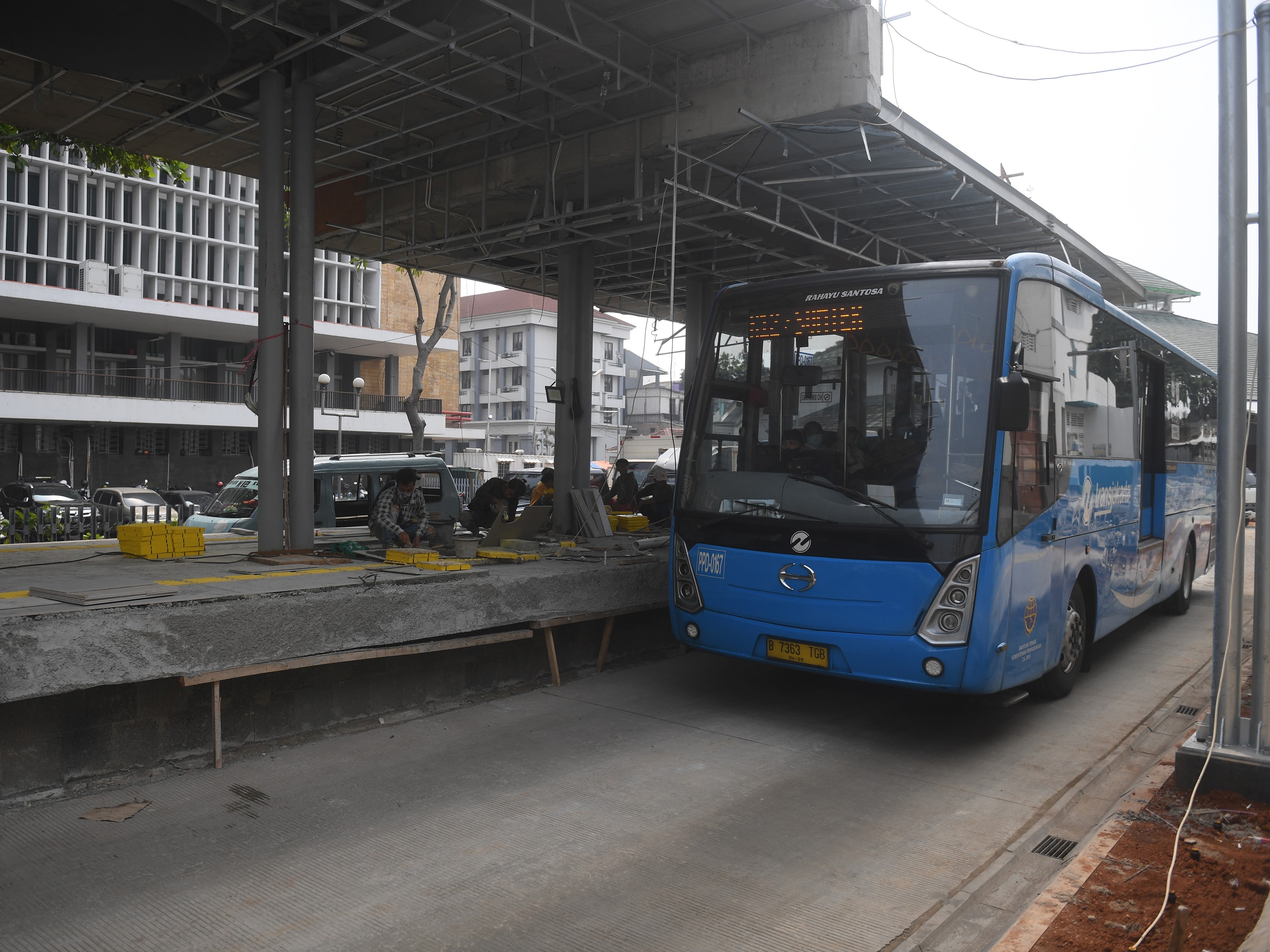 Pekerja menyelesaikan pembangunan halte Transjakarta di kawasan Kota Tua, Jakarta, Jumat (22/7/2022). 