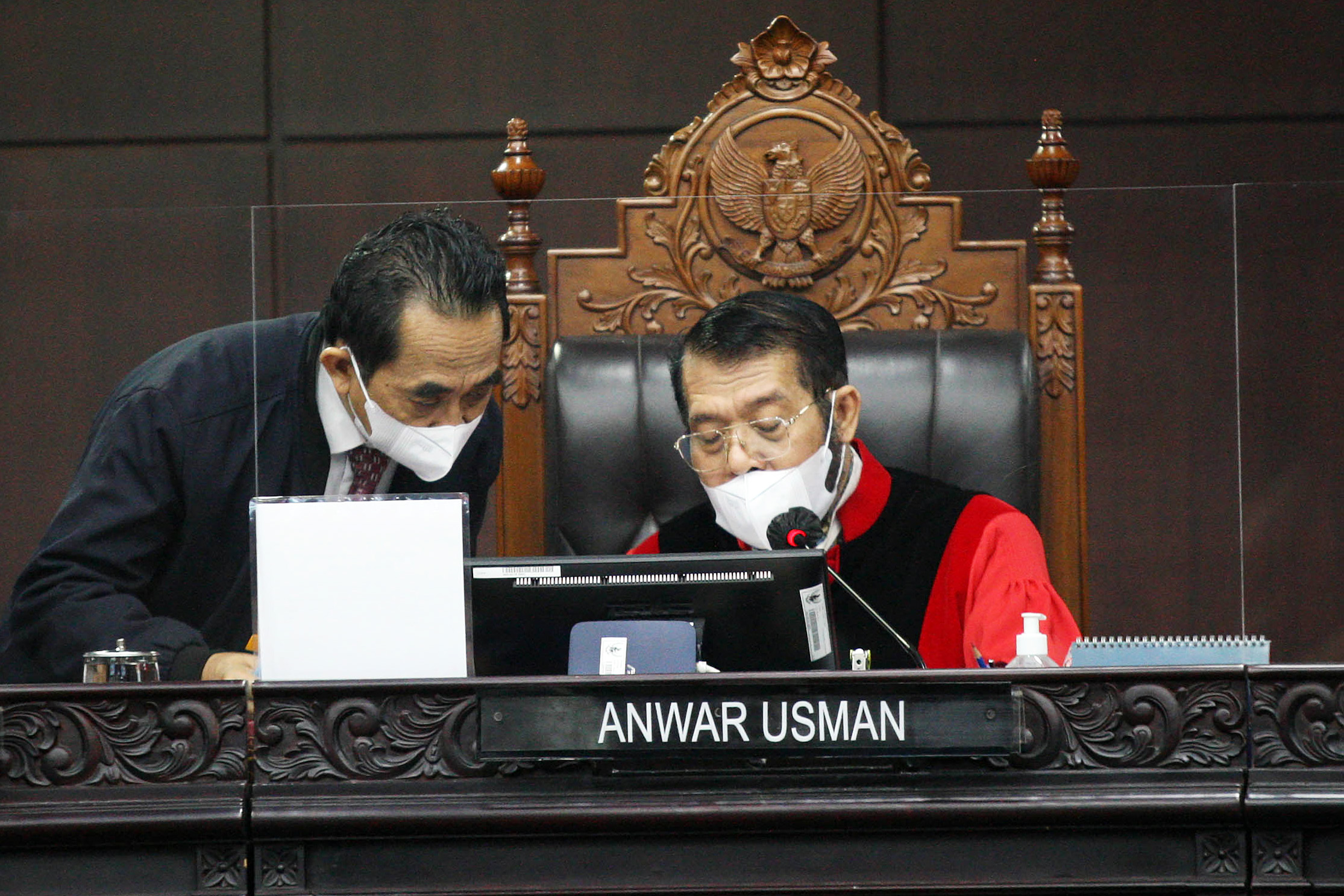 Ketua Hakim Konstitusi Anwar Usman berdiskusi dengan panitera di sela-sela persidangan.