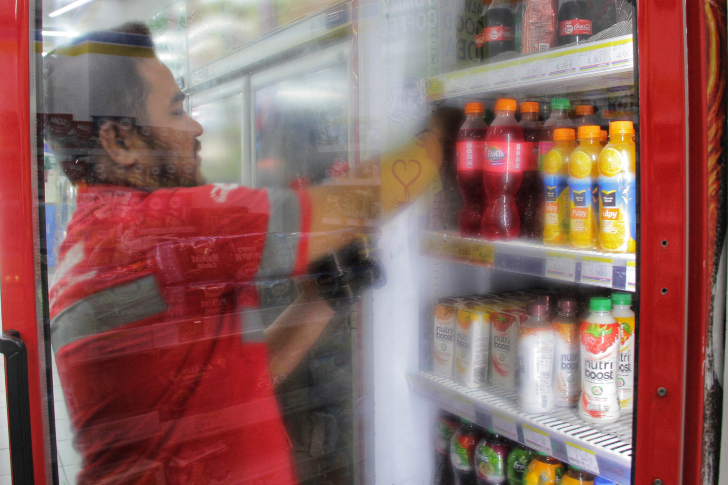 Konsumen mengambil produk minuman dari lemari pendingin di sebuah minimarket yang berada di kawasan Pasar Baru, Jakarta Pusat.